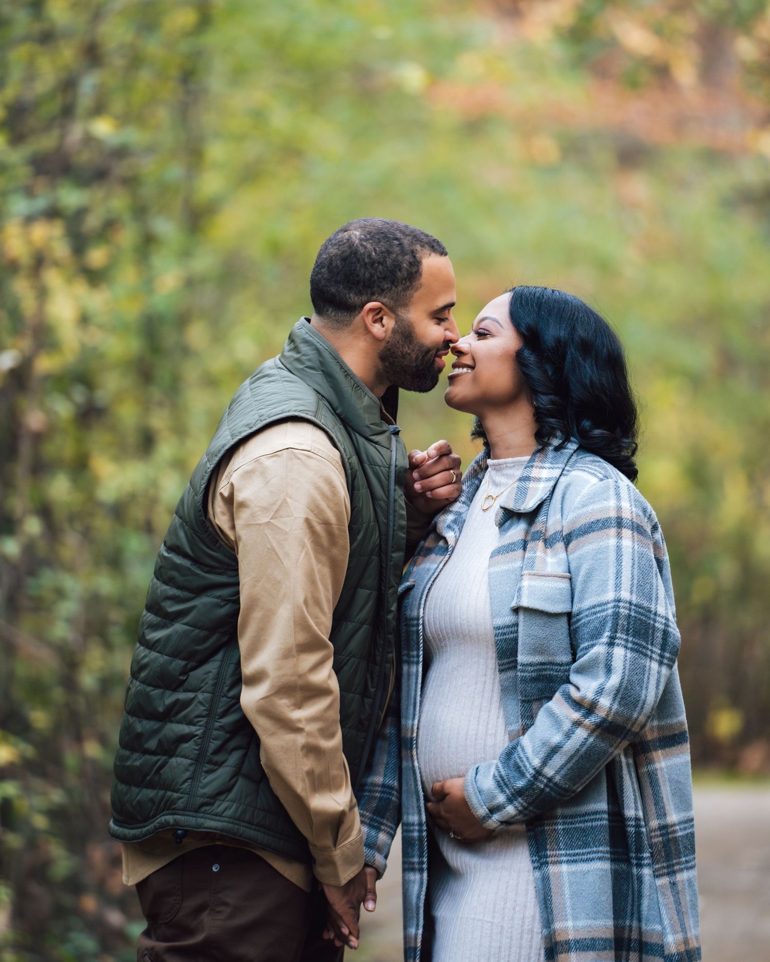 Metro Detroit maternity photographer capturing an expecting couple shares tender moments outdoors in casual winter clothing.