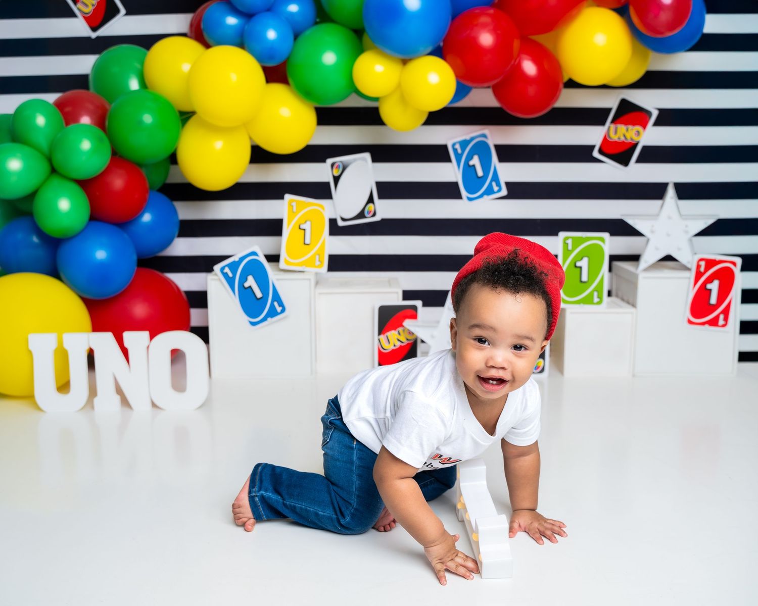 Metro Detroit children photographer photographing a playful toddler in studio Colorful UNO card game themed