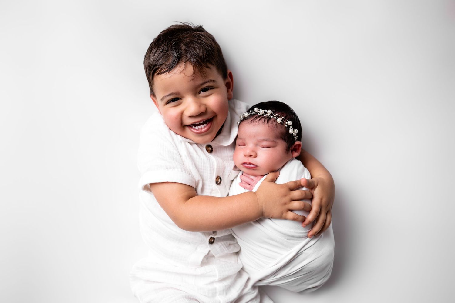 Metro Detroit newborn photographer capturing a peaceful newborn with bug brother portrait in studio