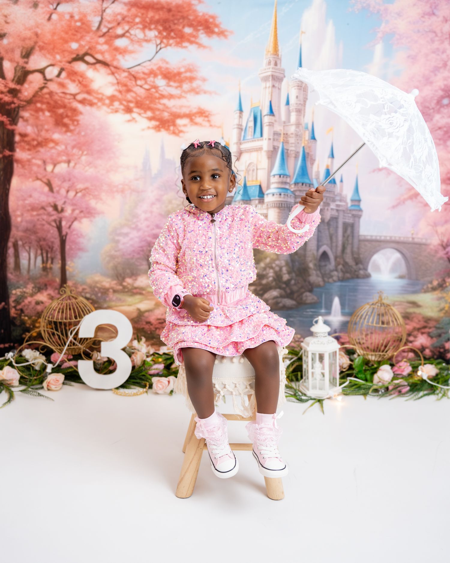 Metro Detroit children photographer photographing a playful toddler in studio A dreamy pink cherry blossom backdrop with Disney castle