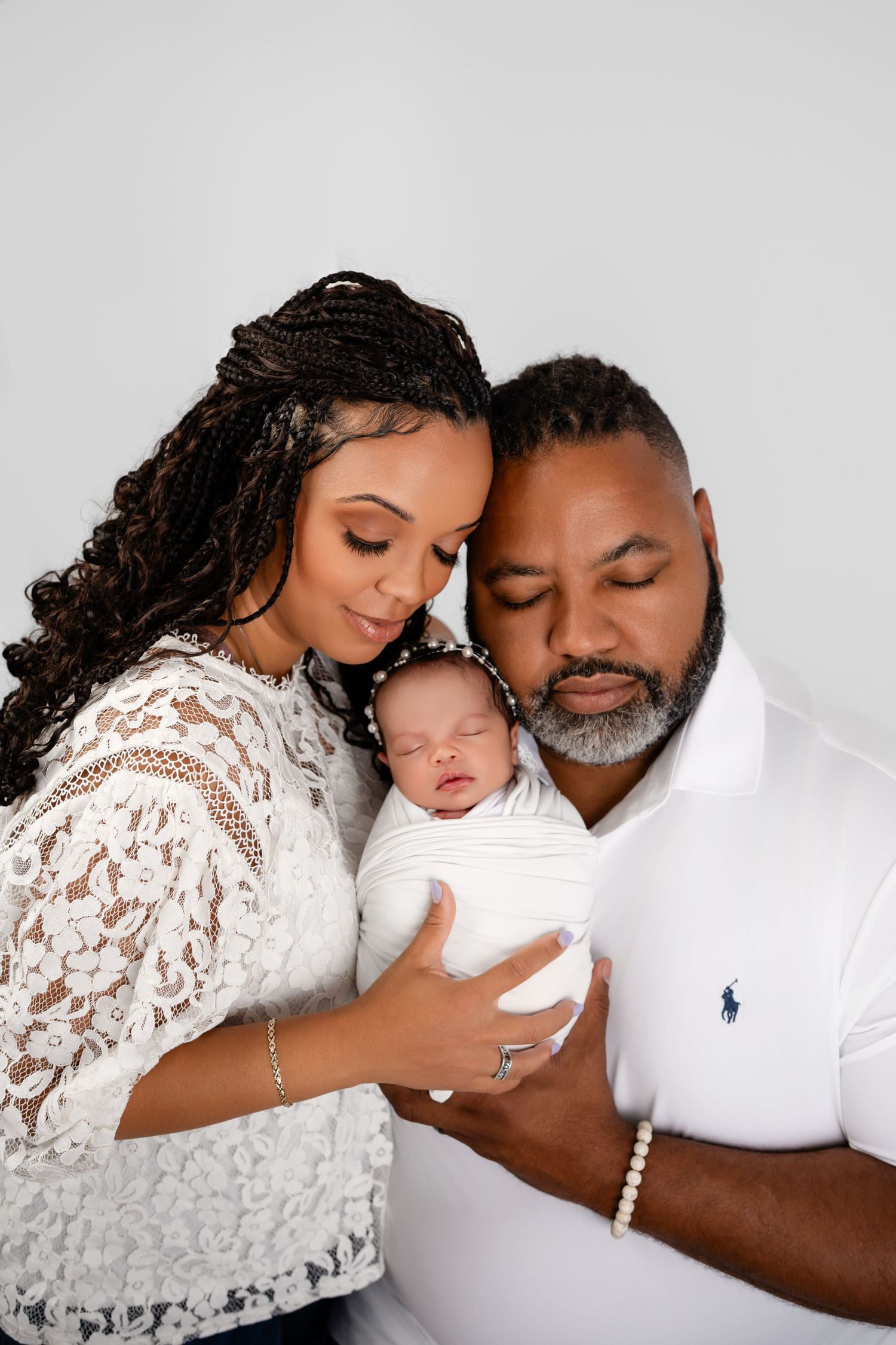 Metro Detroit newborn photographer capturing a peaceful newborn with parents  portrait in studio