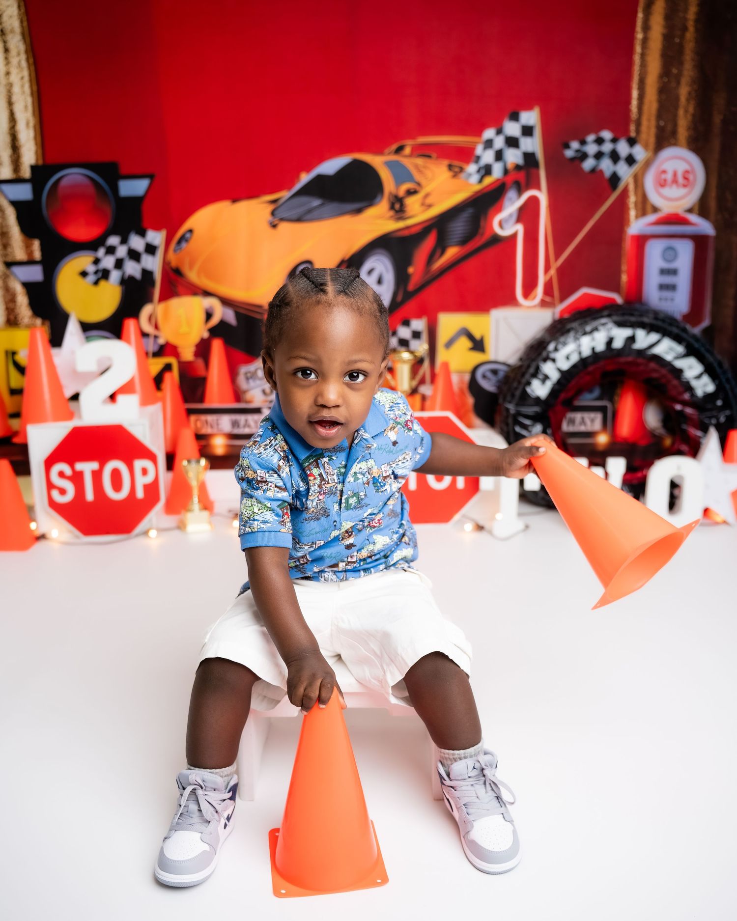 Metro Detroit children photographer Car and racing-themed photoshoot with traffic signs and checkered flags.