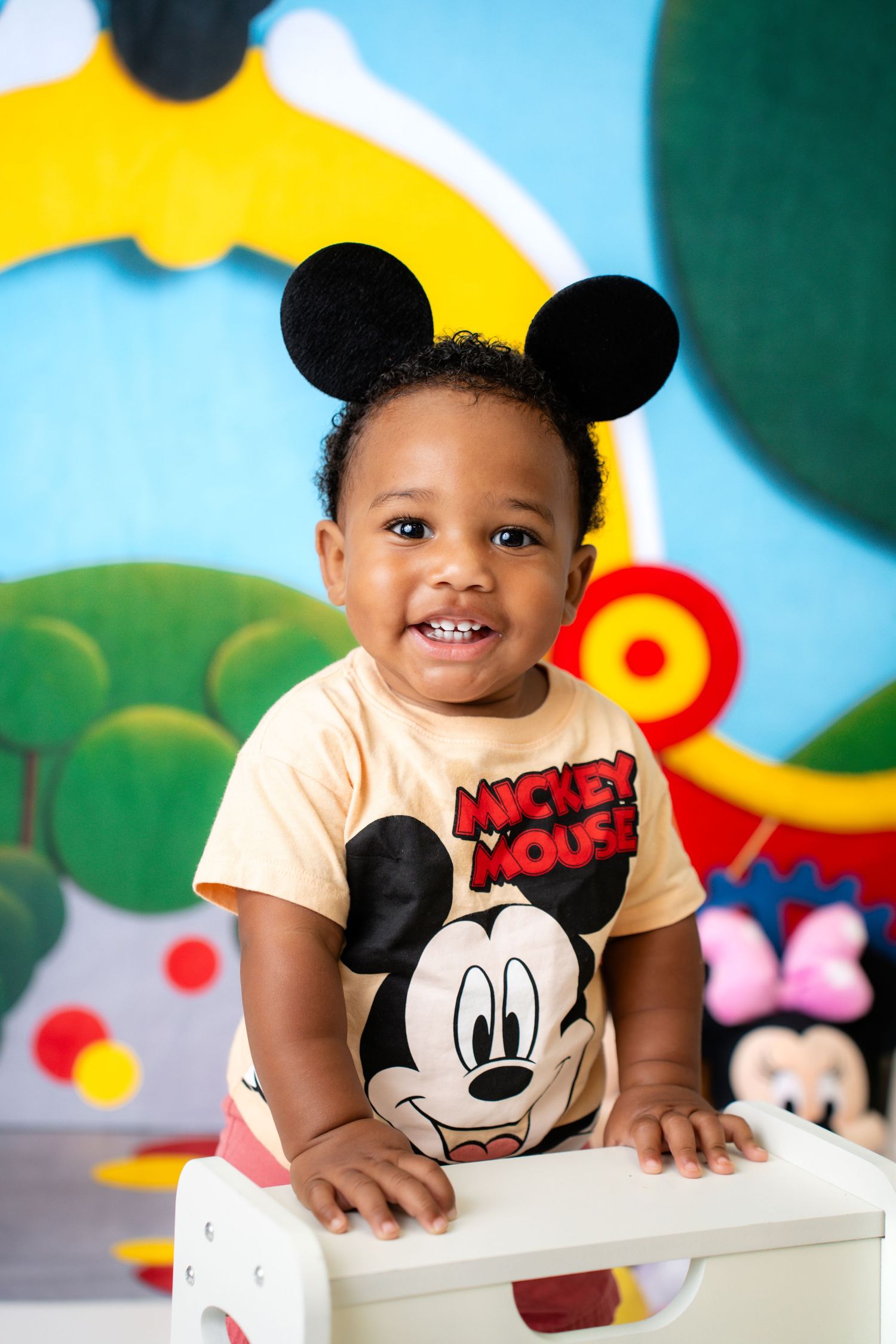 Metro Detroit children photographer Colorful Mickey Mouse themed photo setup with cartoon character decorations.