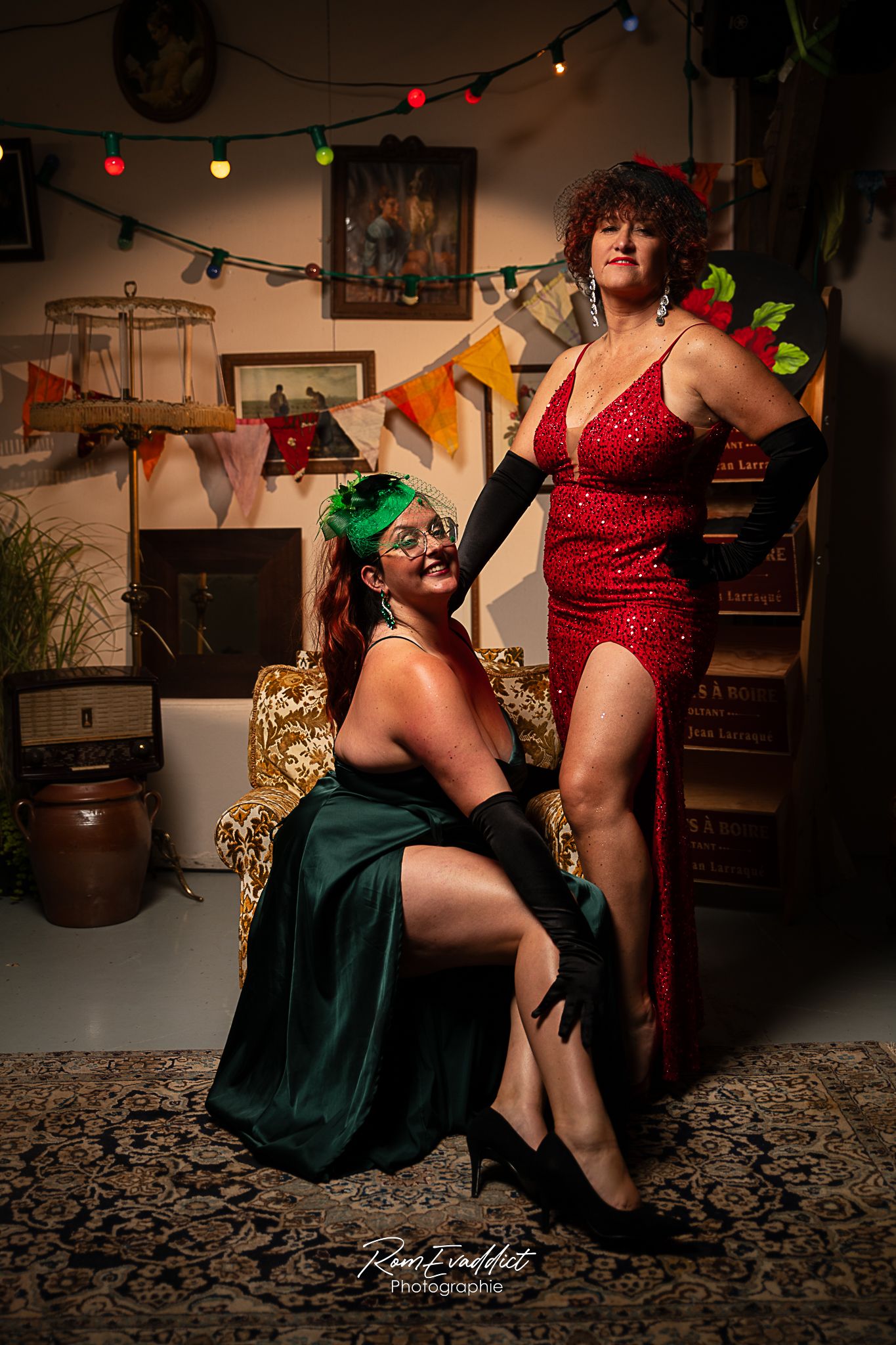 deux femmes, une rousse cheveux long robe de soirée verte assise sur un fauteuil, une rousse bouclée robe longue de soirée, rouge