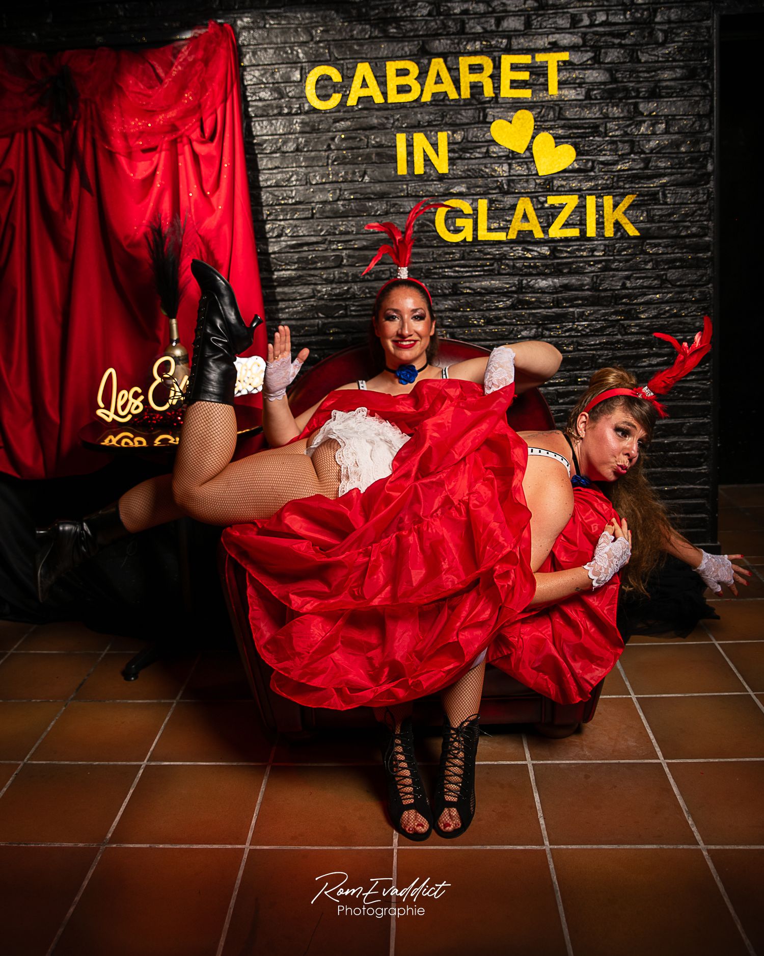deux danseuse de cancan robe rouge, haut blanc et coiffe plume rouge en position humoristique pour photocall événement cabaret in glazik