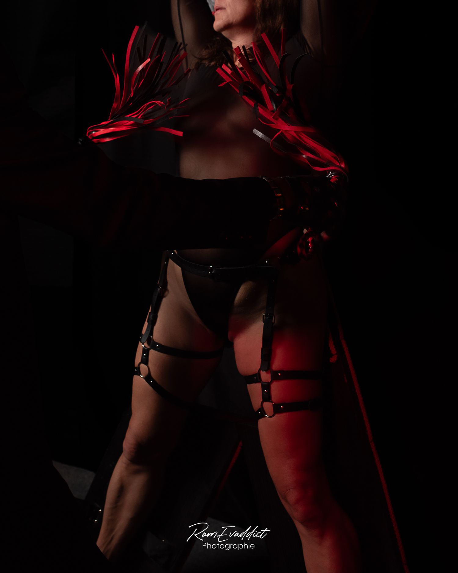 femme en body et harnais cuir noir devant croix st andré fouettée par des martinet lanière cuire noir-BDSM-shooting couple sur mesure