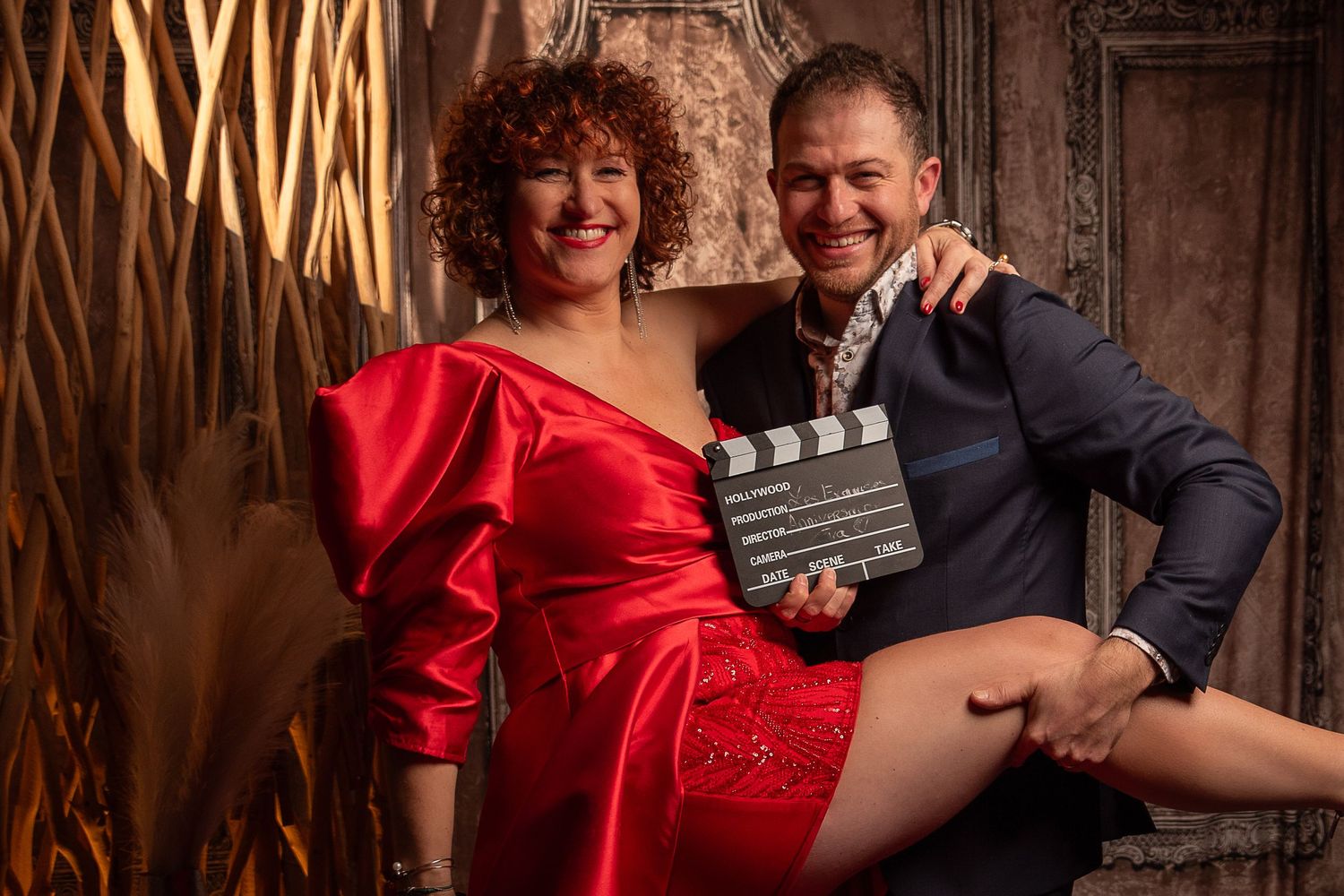 couple femme en robe de soirée rouge homme en costume bleu chemise blanche. homme tenant la jambe de la femme- portrait boudoir