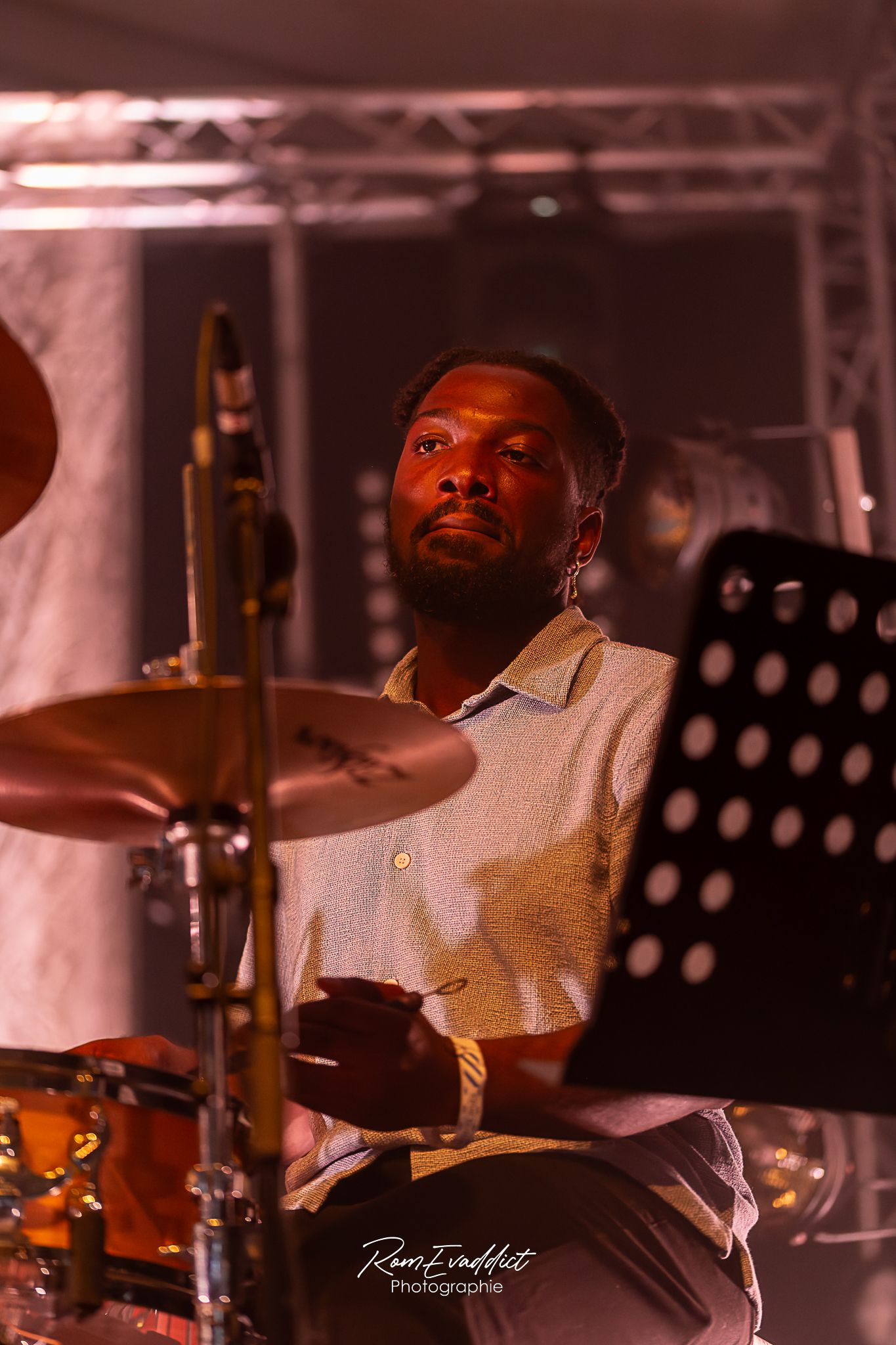 Homme créole musicien batteur en polo beige jouant d ela batterie durant concert de jazz- photo concert spectacle événementiel