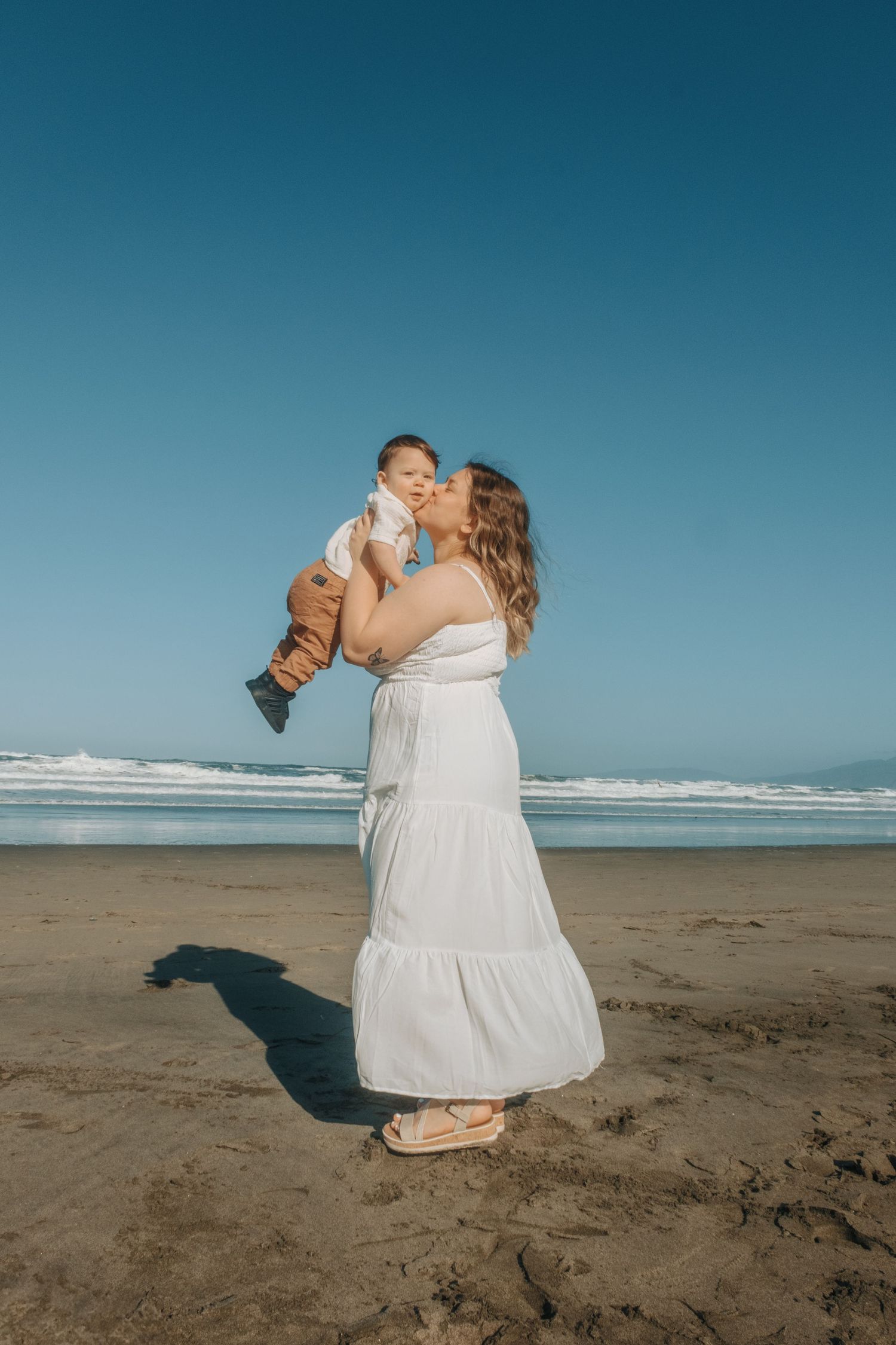 Candid beach photography sequence showing joyful moments between two people on sandy shores.