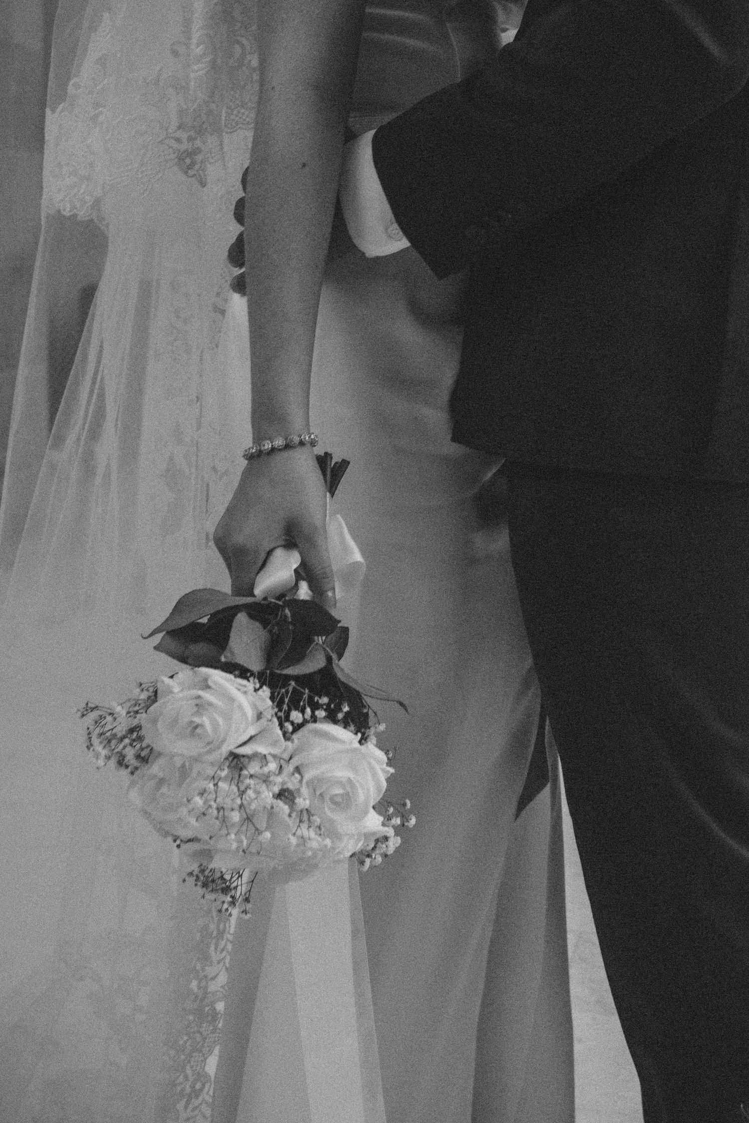 Elegant wedding details showing white floral wrist corsages and formal attire.