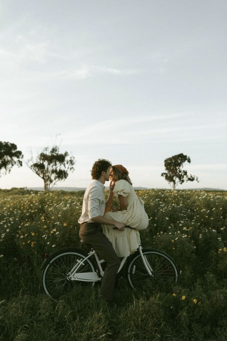 Romantic bicycle date in a blooming wildflower meadow during sunset.