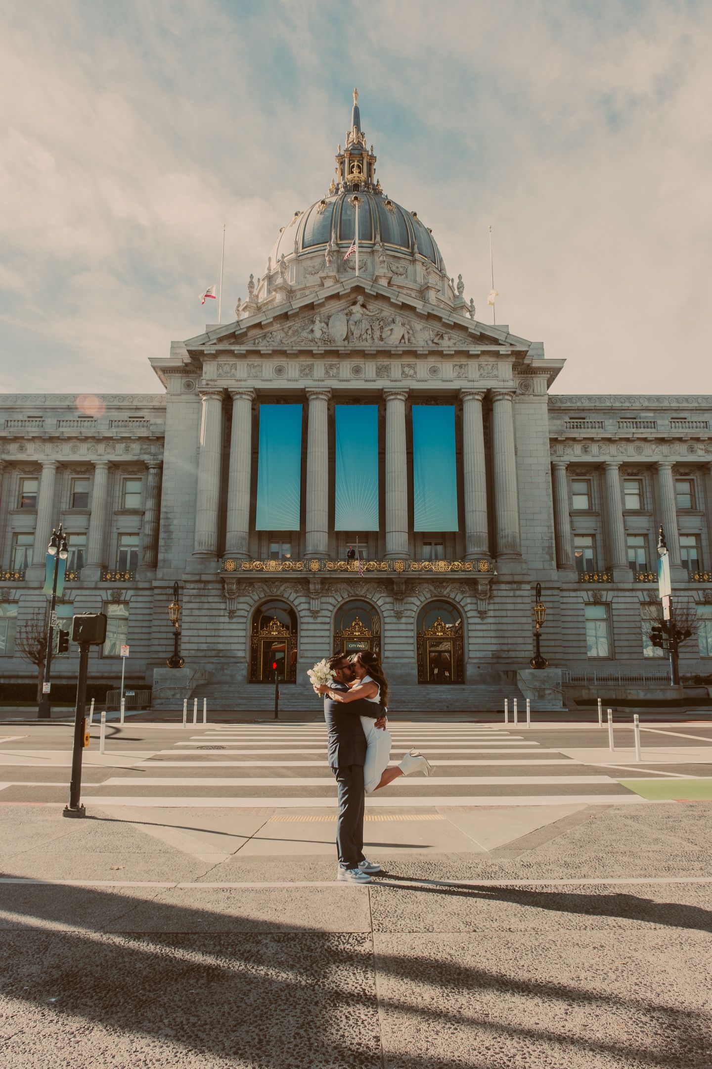 San Francisco City Hall's grand exterior architecture with its iconic dome against a cloudy sky.