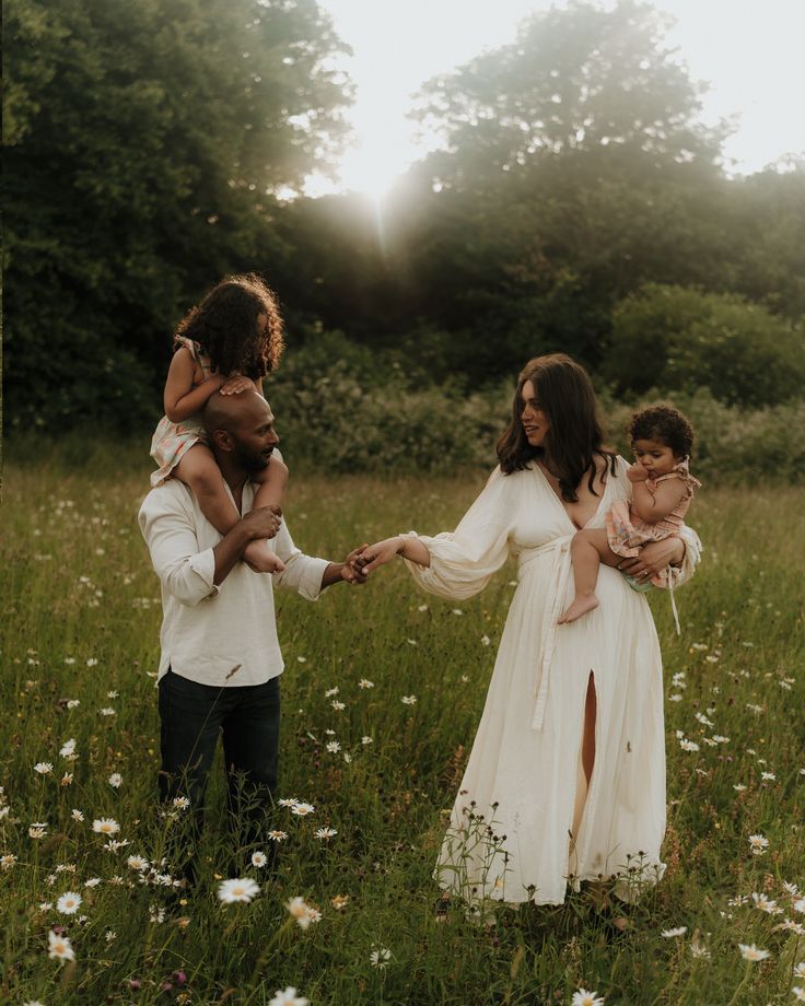 Family sharing tender moment in wildflower meadow at sunset.