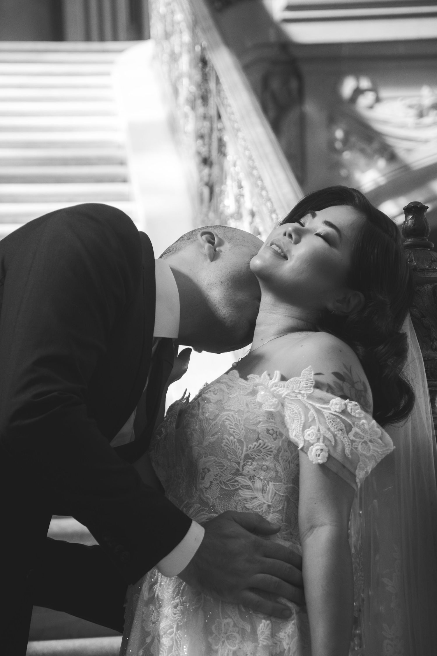 Romantic black and white wedding photo capturing an intimate moment between newlyweds.