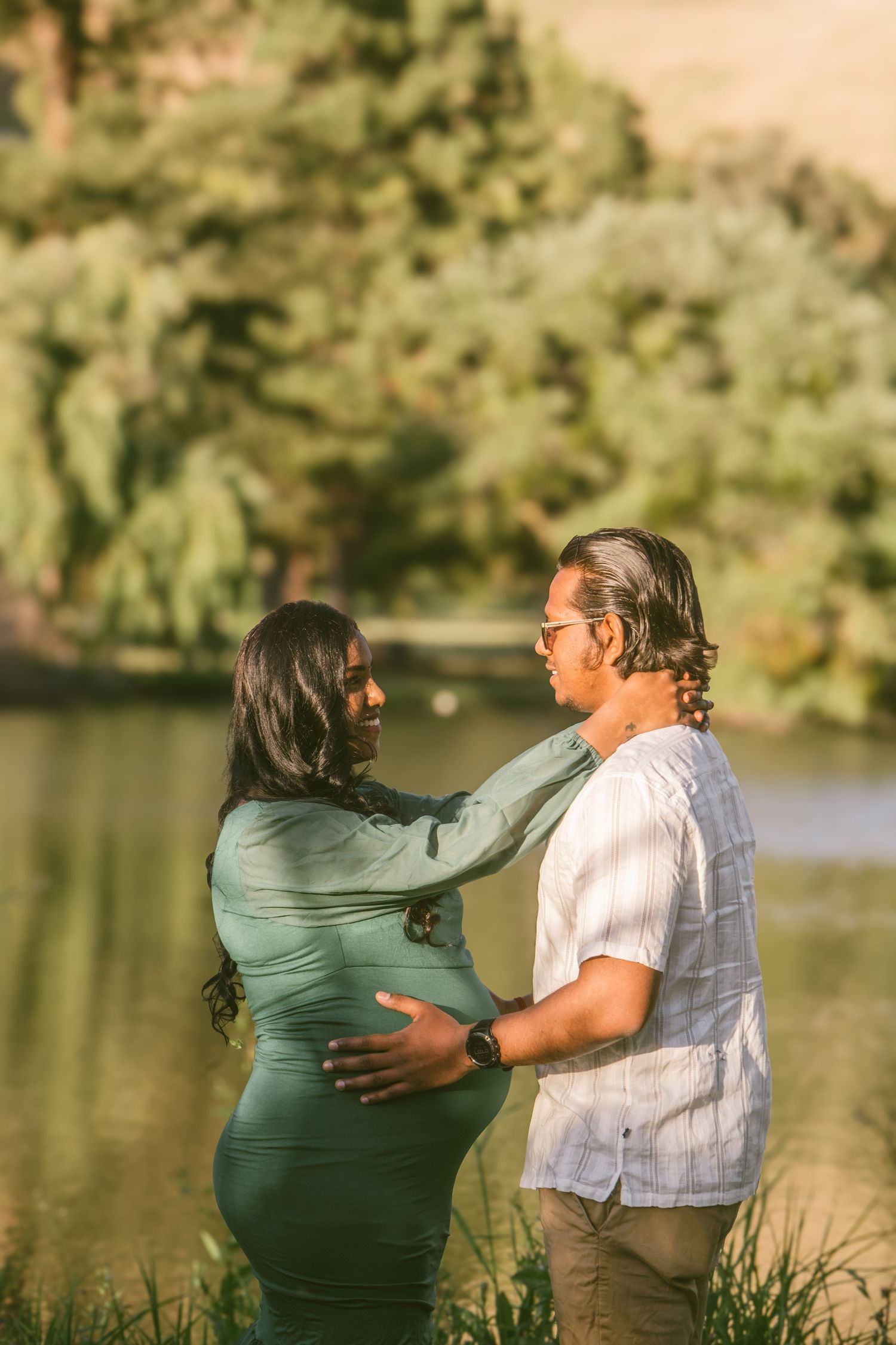 Couple dancing together by lakeside during sunset.