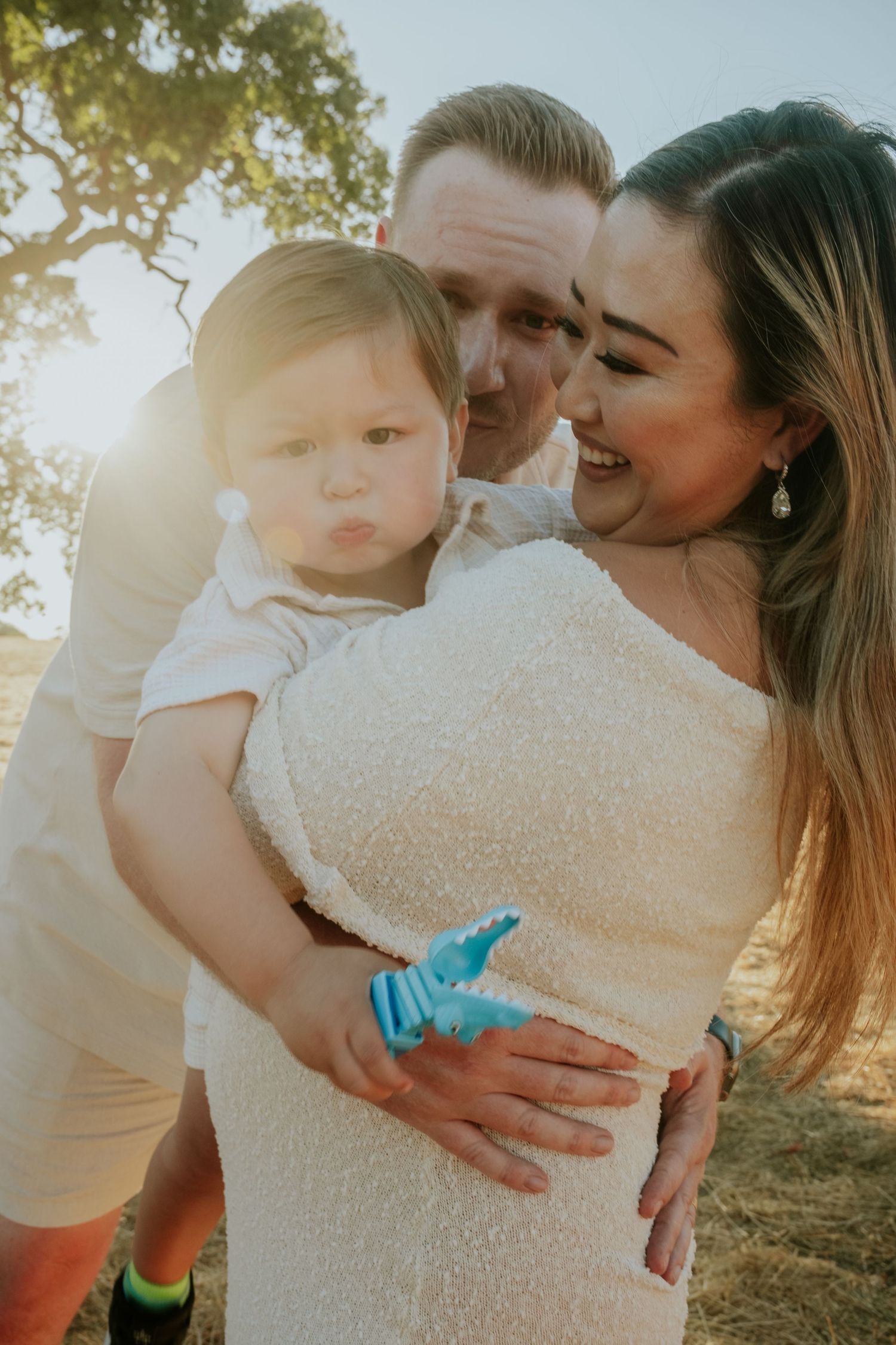 A tender family moment captured in warm sunlight with gentle embraces.
