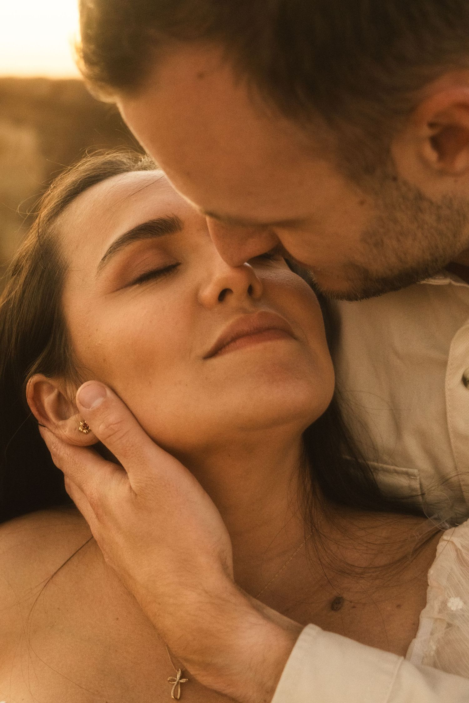 Intimate romantic couple sharing tender moments in warm lighting.