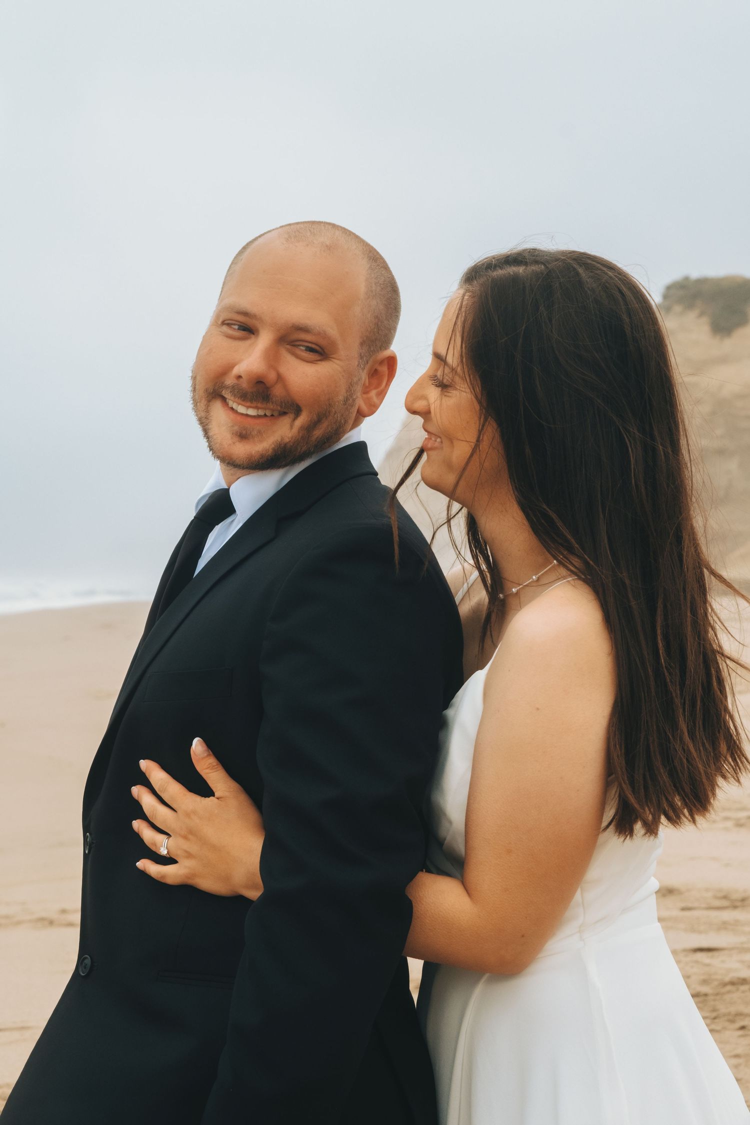 Romantic dance sequence captured on a beach showing joyful movement and laughter.