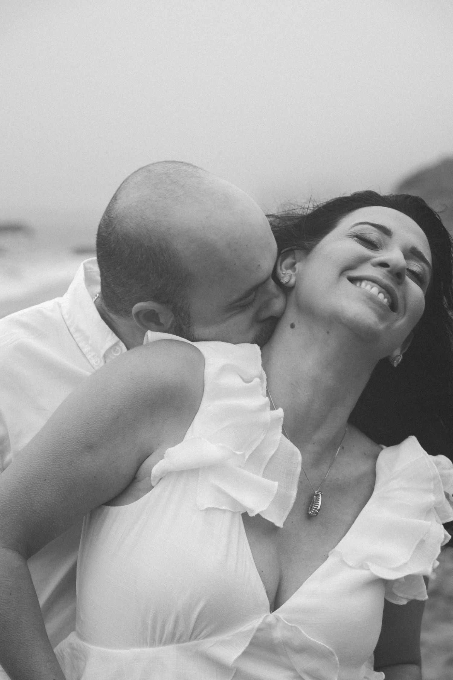Black and white sequence showing tender moments between a couple in white clothing.