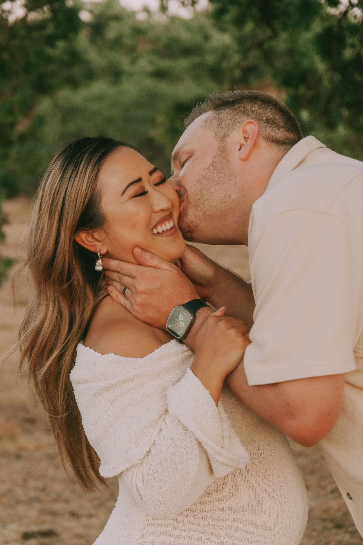 A couple shares intimate kisses during a golden hour photoshoot.