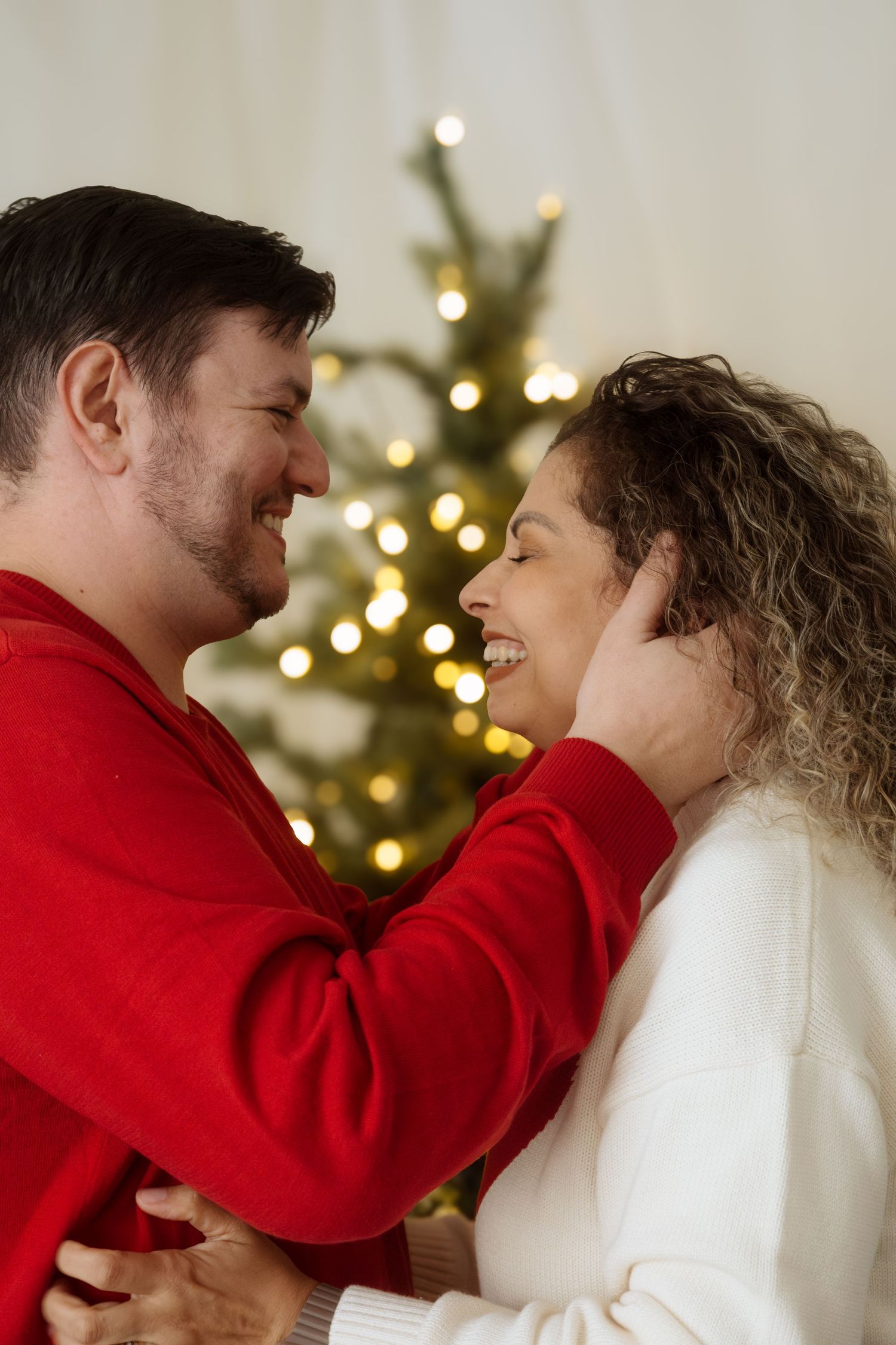 Playful couple portraits with festive Christmas decor and cozy sweaters.