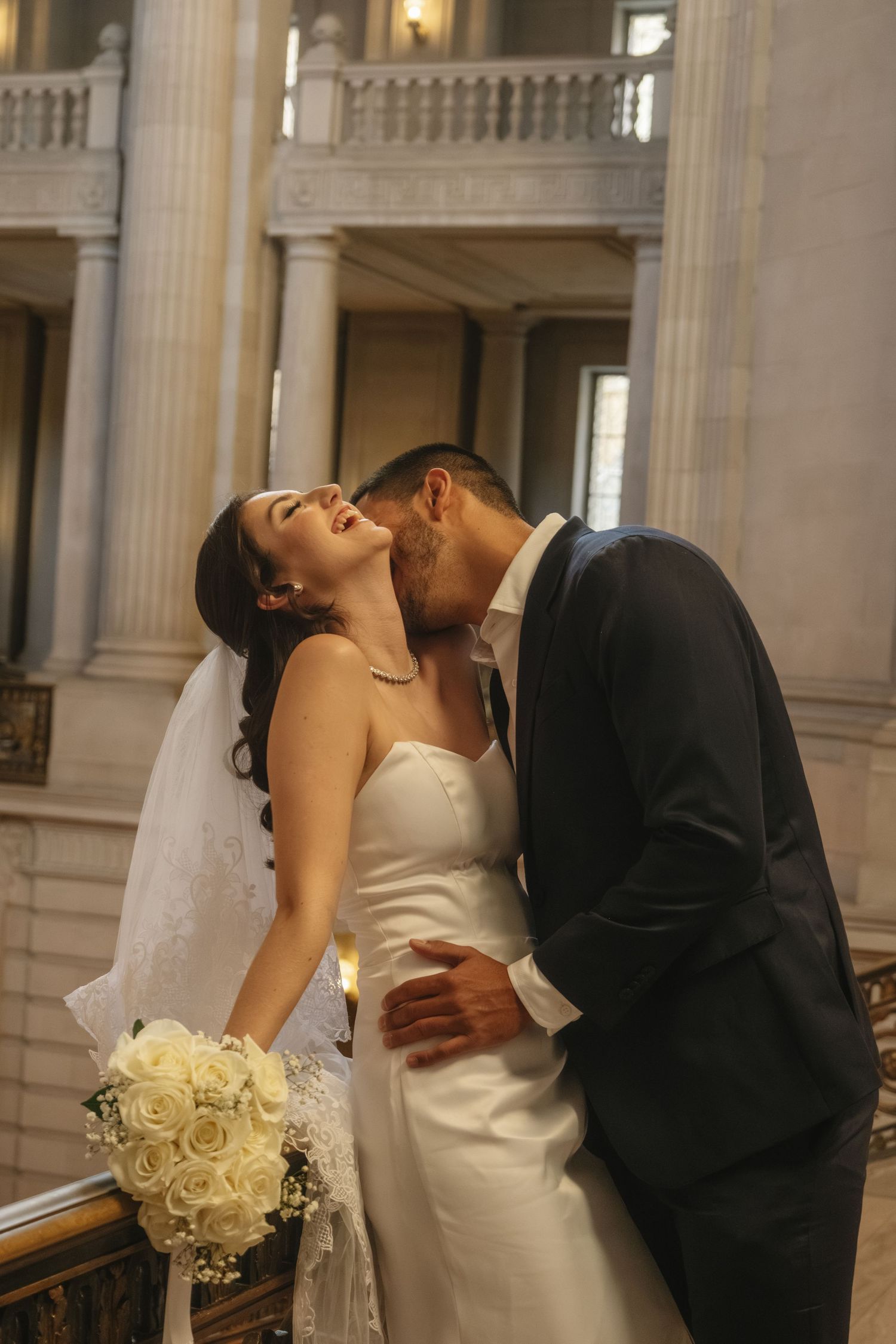 Romantic wedding moment with bride in white dress holding rose bouquet.