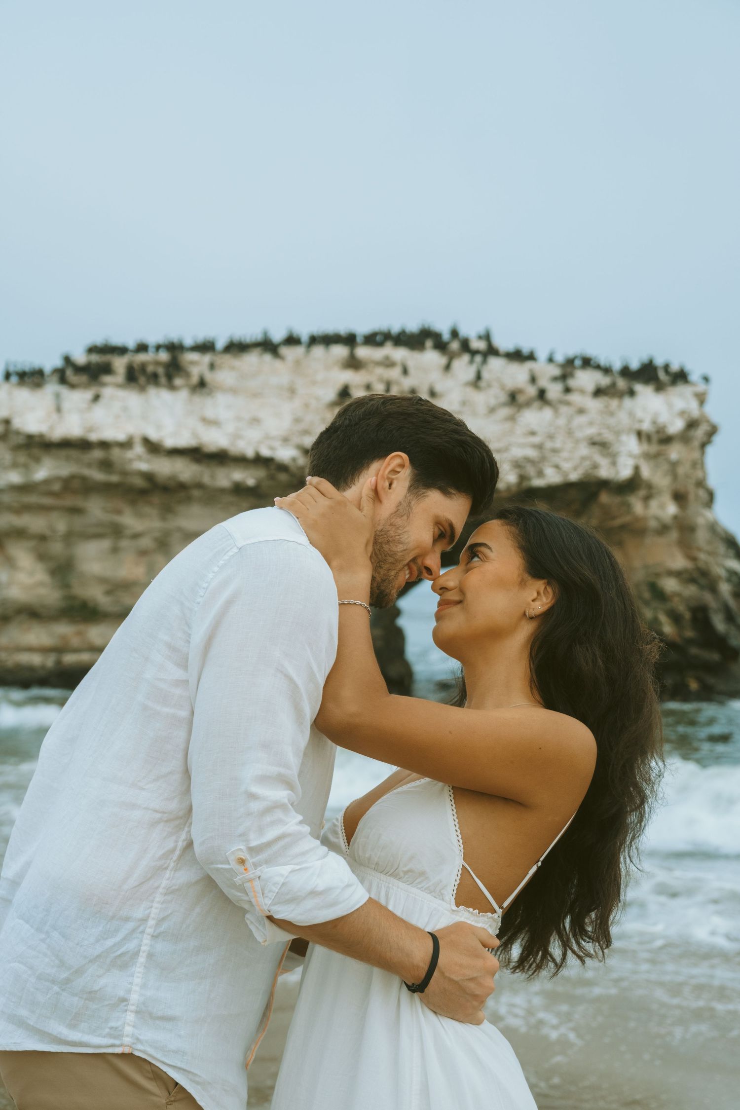 Intimate coastal portrait session with dramatic rocky cliffs and ocean scenery.
