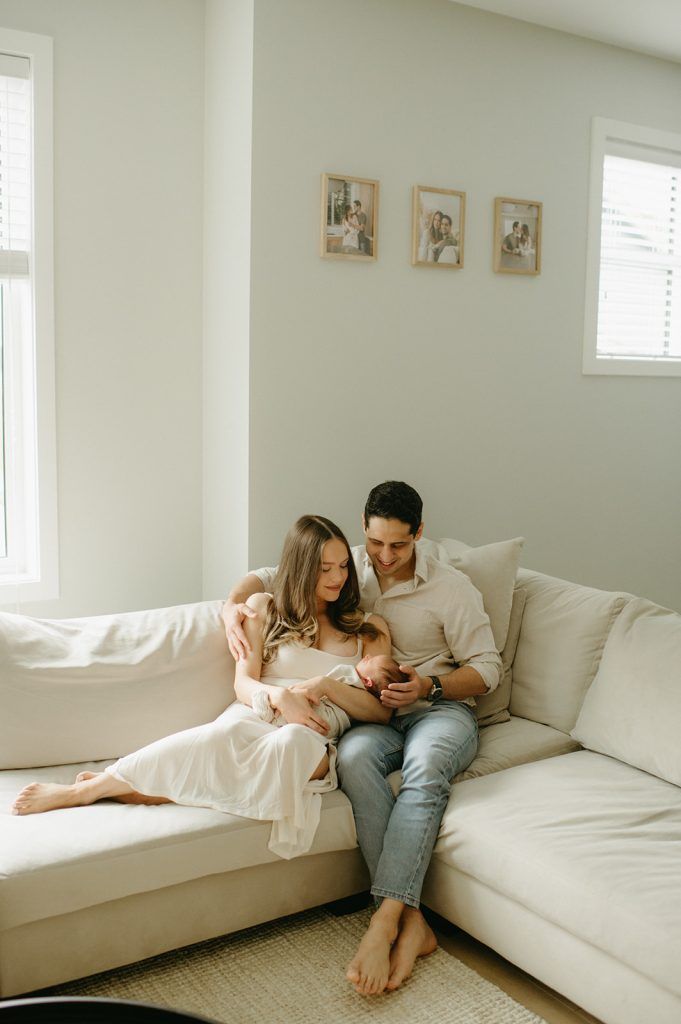 A series of intimate lifestyle photos showing a couple relaxing together on a white couch in a bright minimalist room.