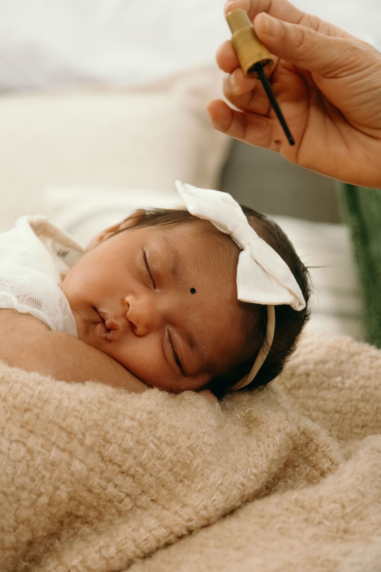 Peaceful sleeping newborn wrapped in cozy blanket during photo session.