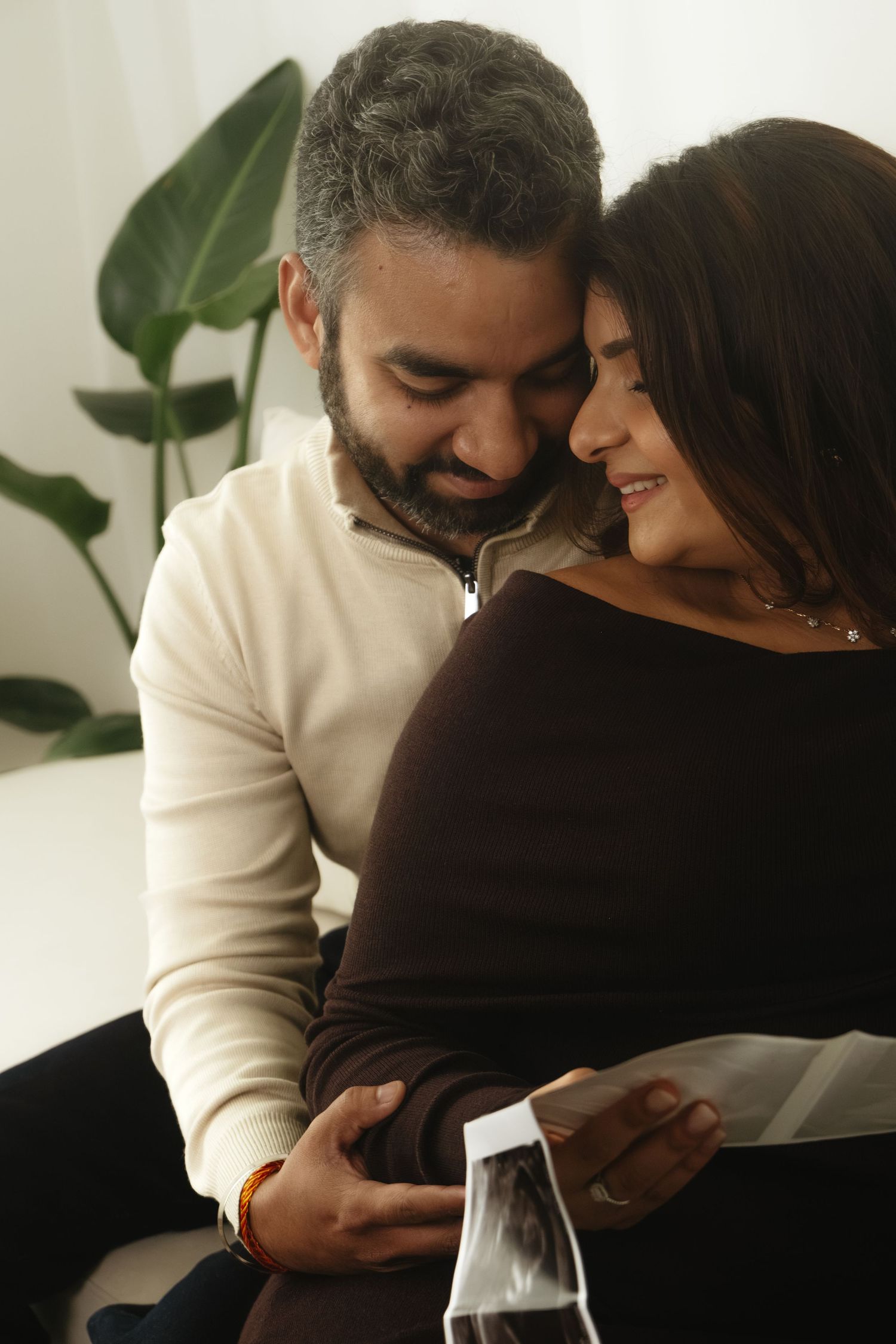 An intimate moment shared while looking at pregnancy ultrasound photos.