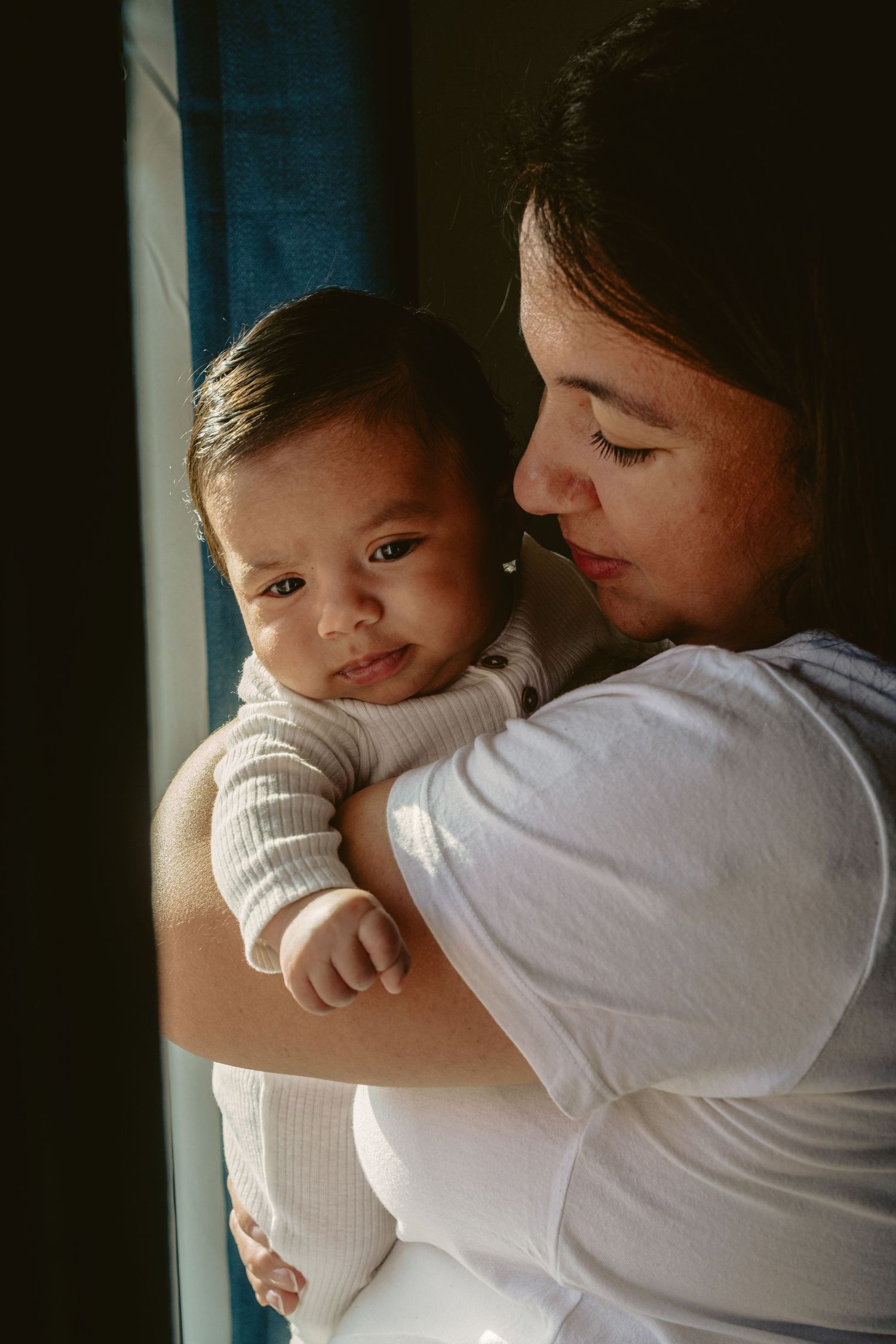 Two people sharing a tender embrace in soft natural lighting.