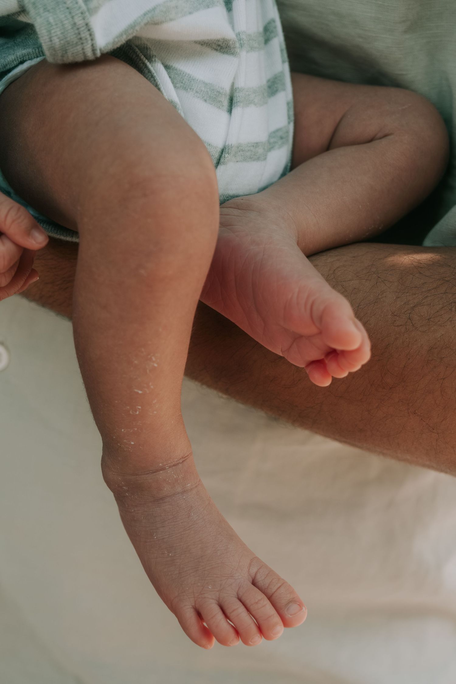 Close-up of tiny baby feet against a white background showing delicate toes and soft skin.