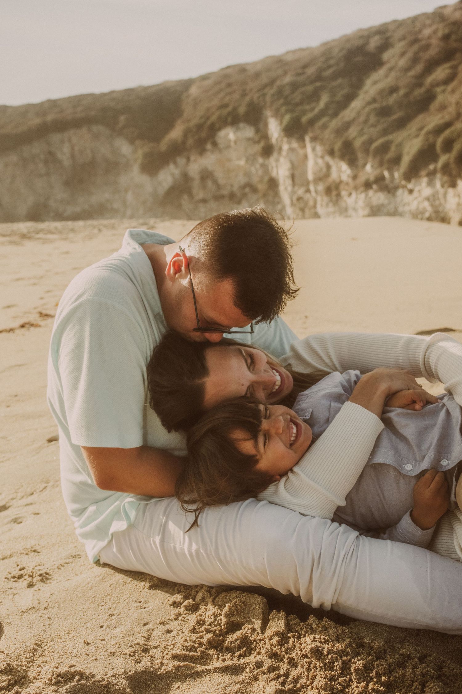 Romantic sequence of a couple lying on sandy beach at sunset.