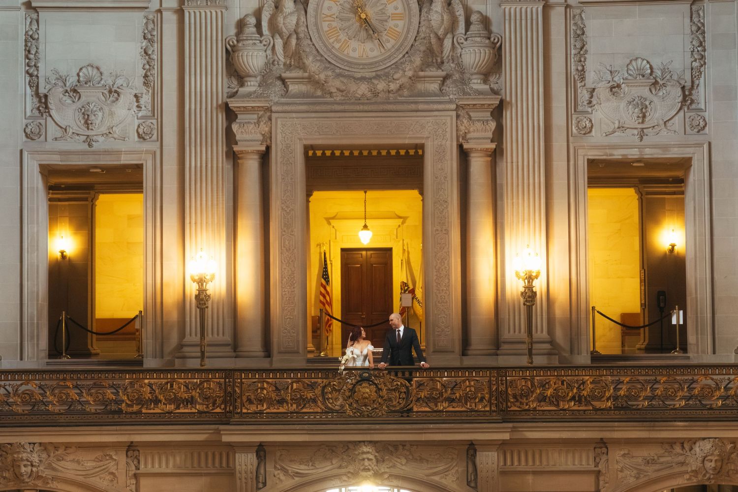 Grand marble staircase and ornate interior architecture of City Hall illuminated by warm lighting.