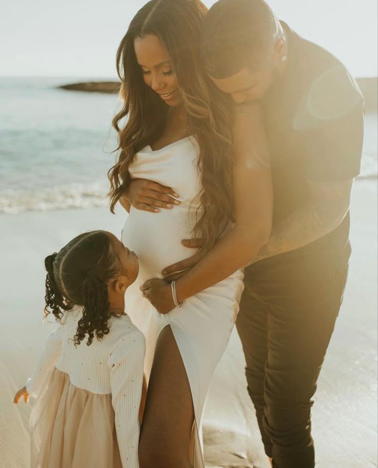 Family sharing tender moment in sunlit beach setting.