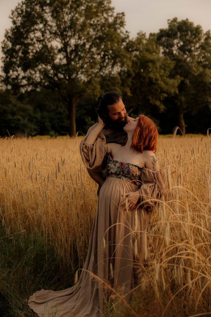 Romantic couple embracing in golden wheat field during sunset photoshoot.