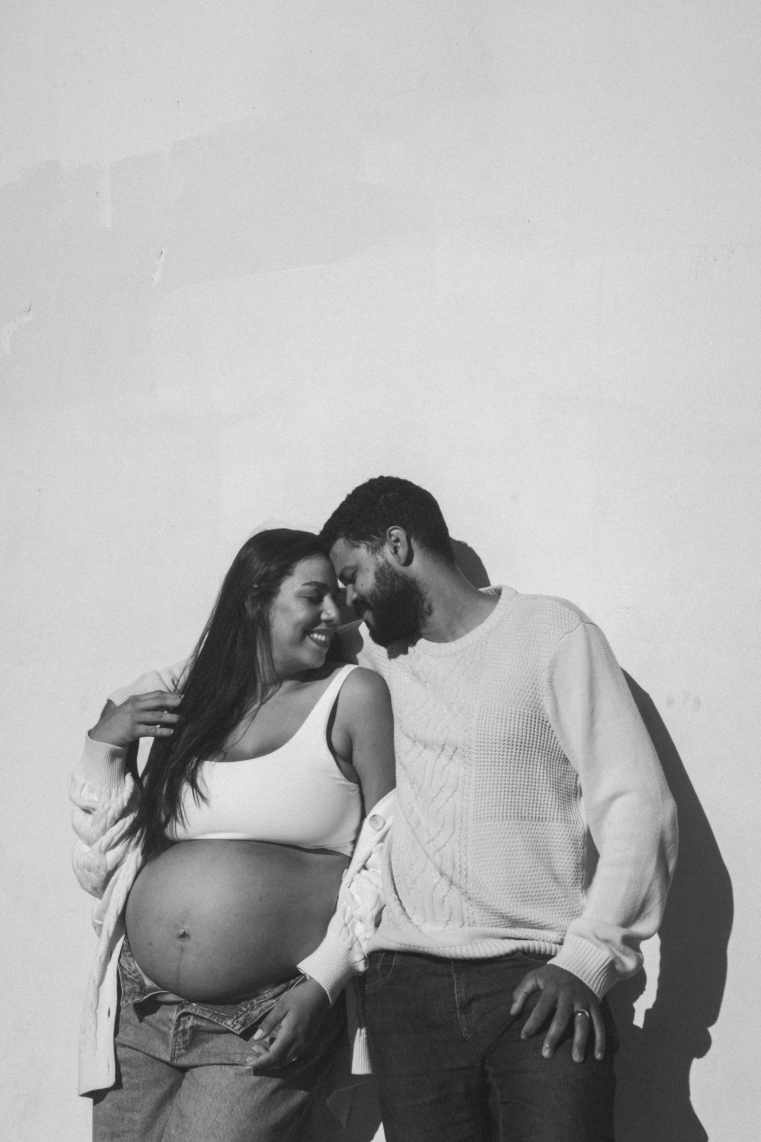 A series of intimate black and white maternity photos showing a couple's tender moments.