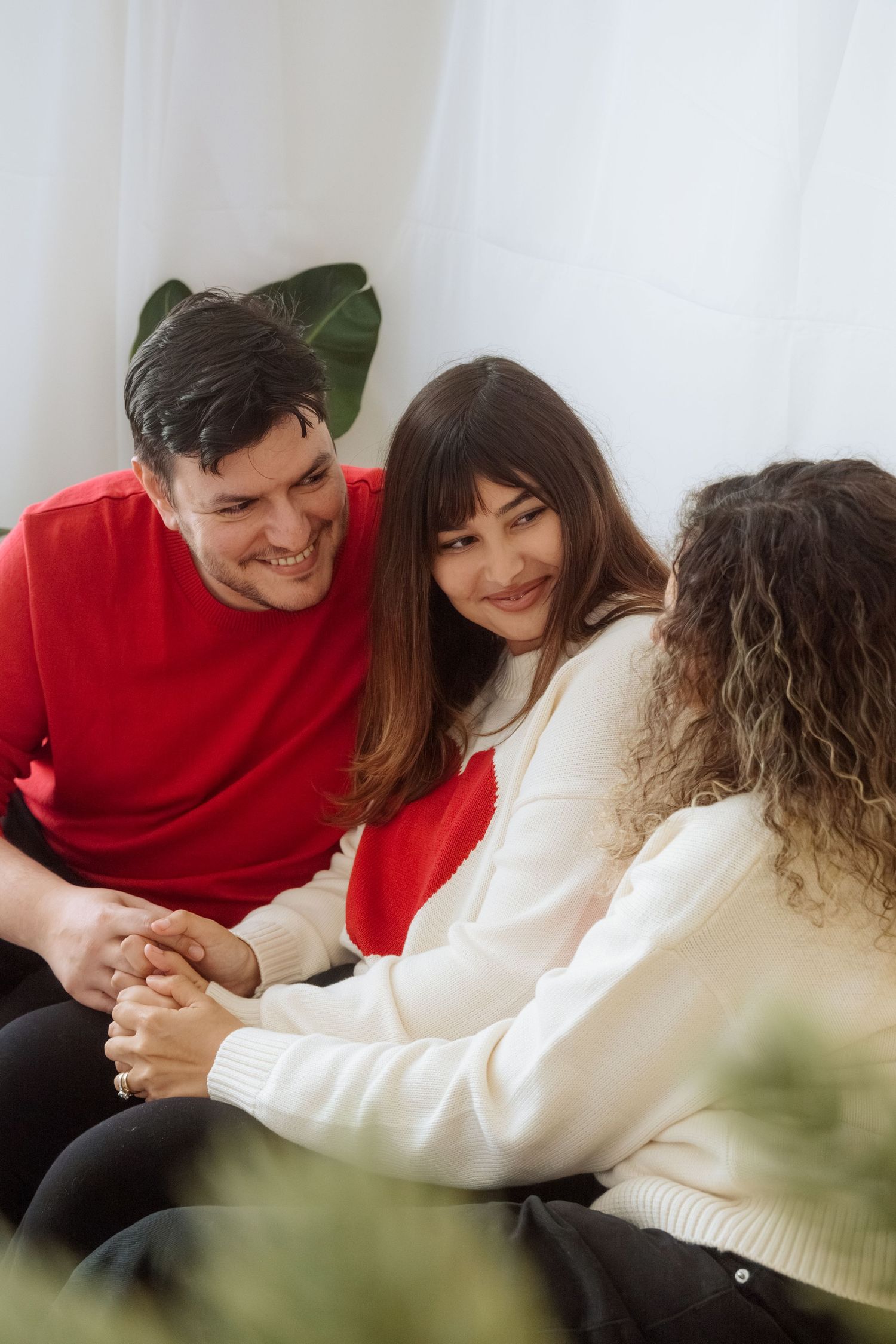 Intimate holiday photoshoot with friends lounging in coordinated winter outfits.
