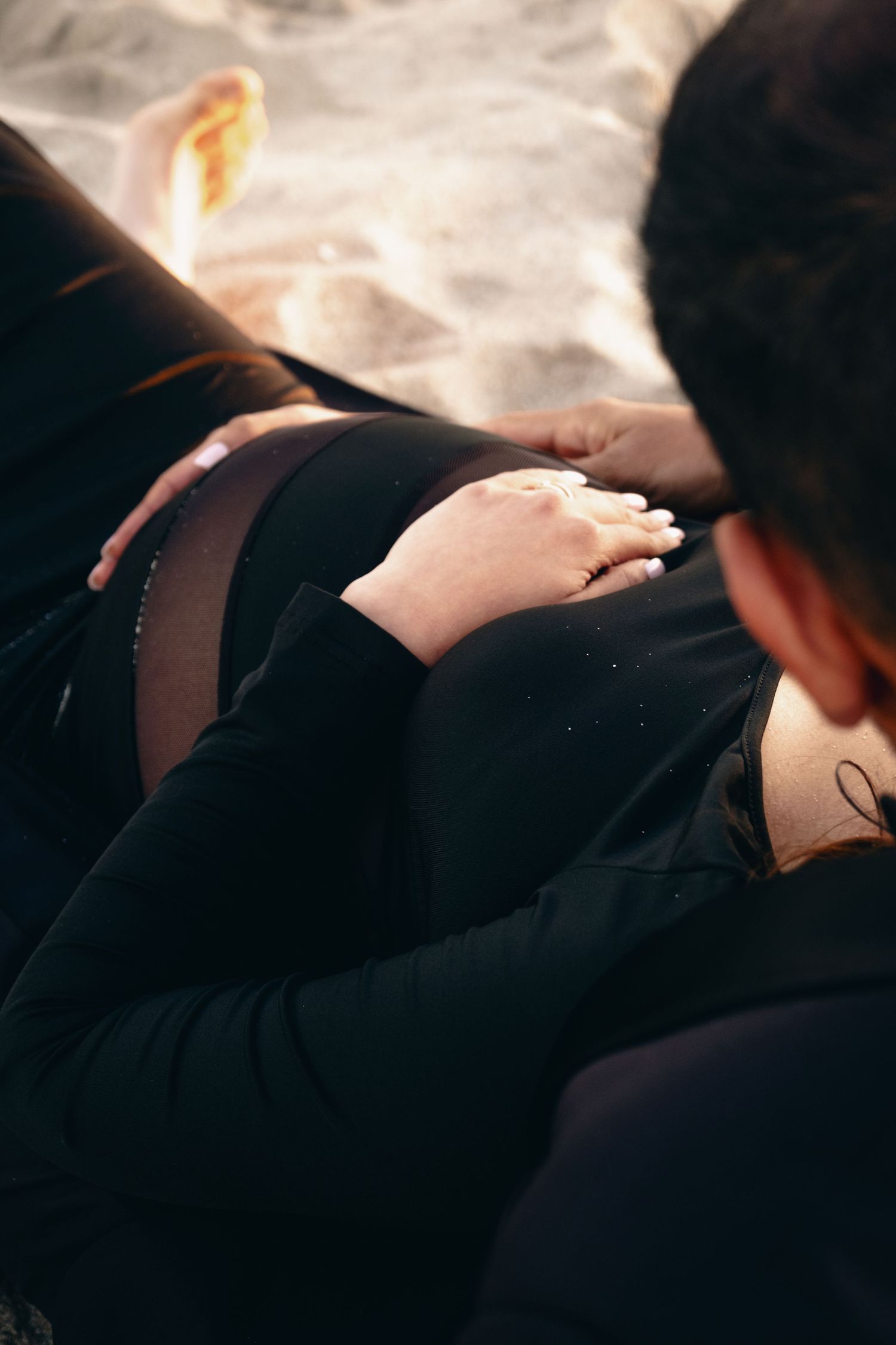 An artistic black and white maternity photo session on a beach.