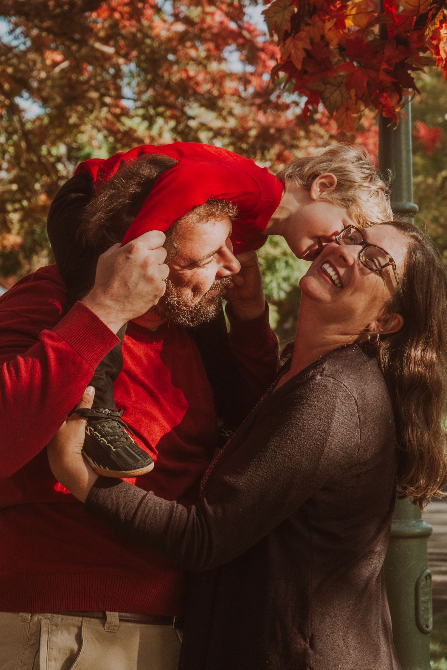 A romantic autumn photoshoot with vibrant red maple leaves in the background.