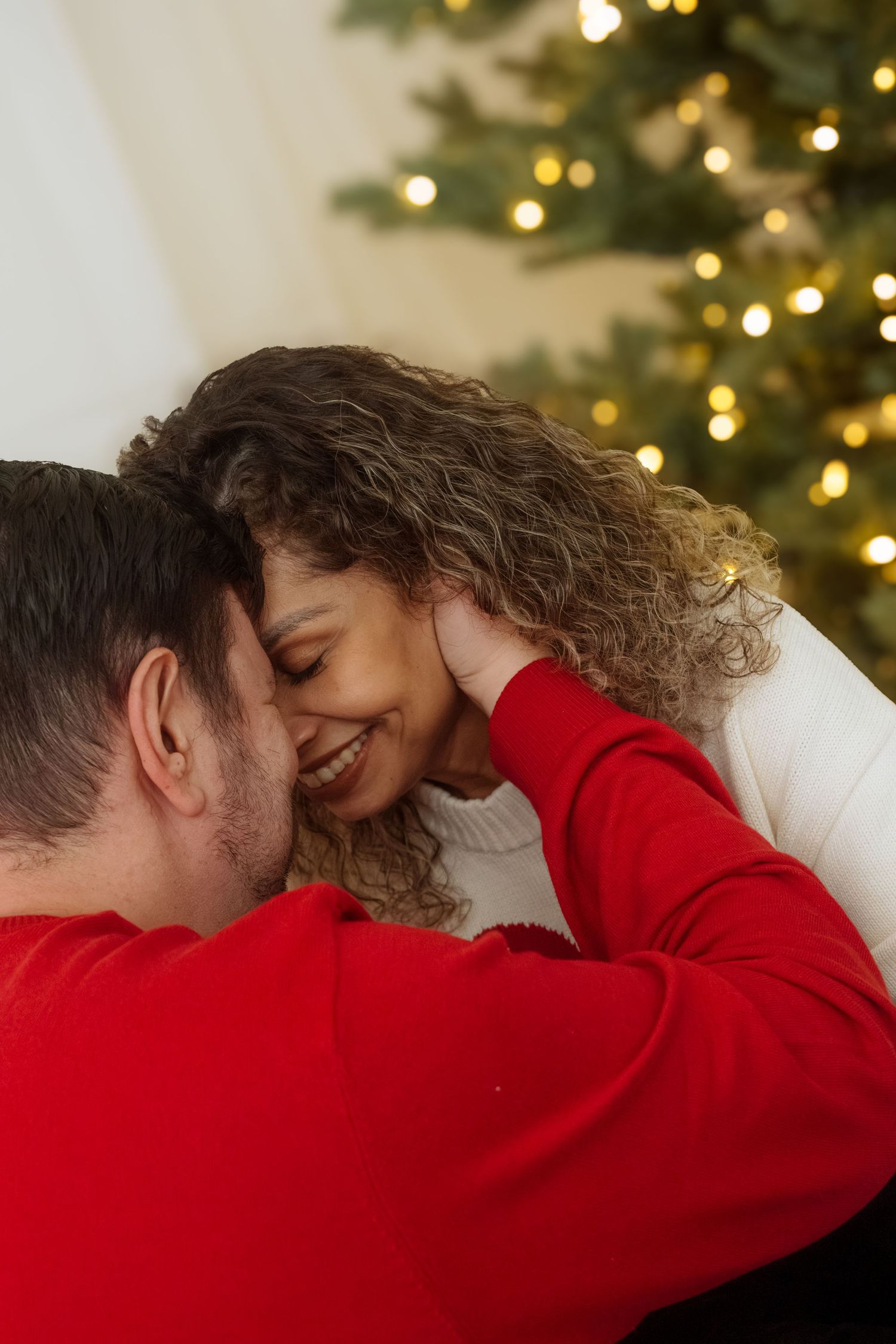 Romantic holiday photos with Christmas lights twinkling in background.