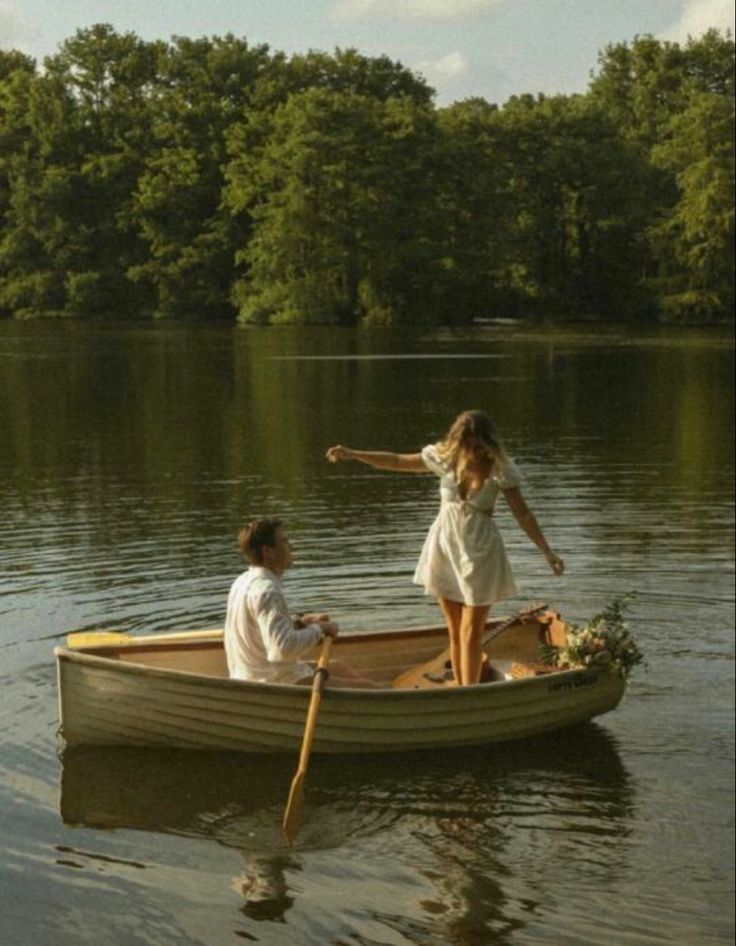 Peaceful scene of people rowing wooden boats on a serene lake surrounded by trees.
