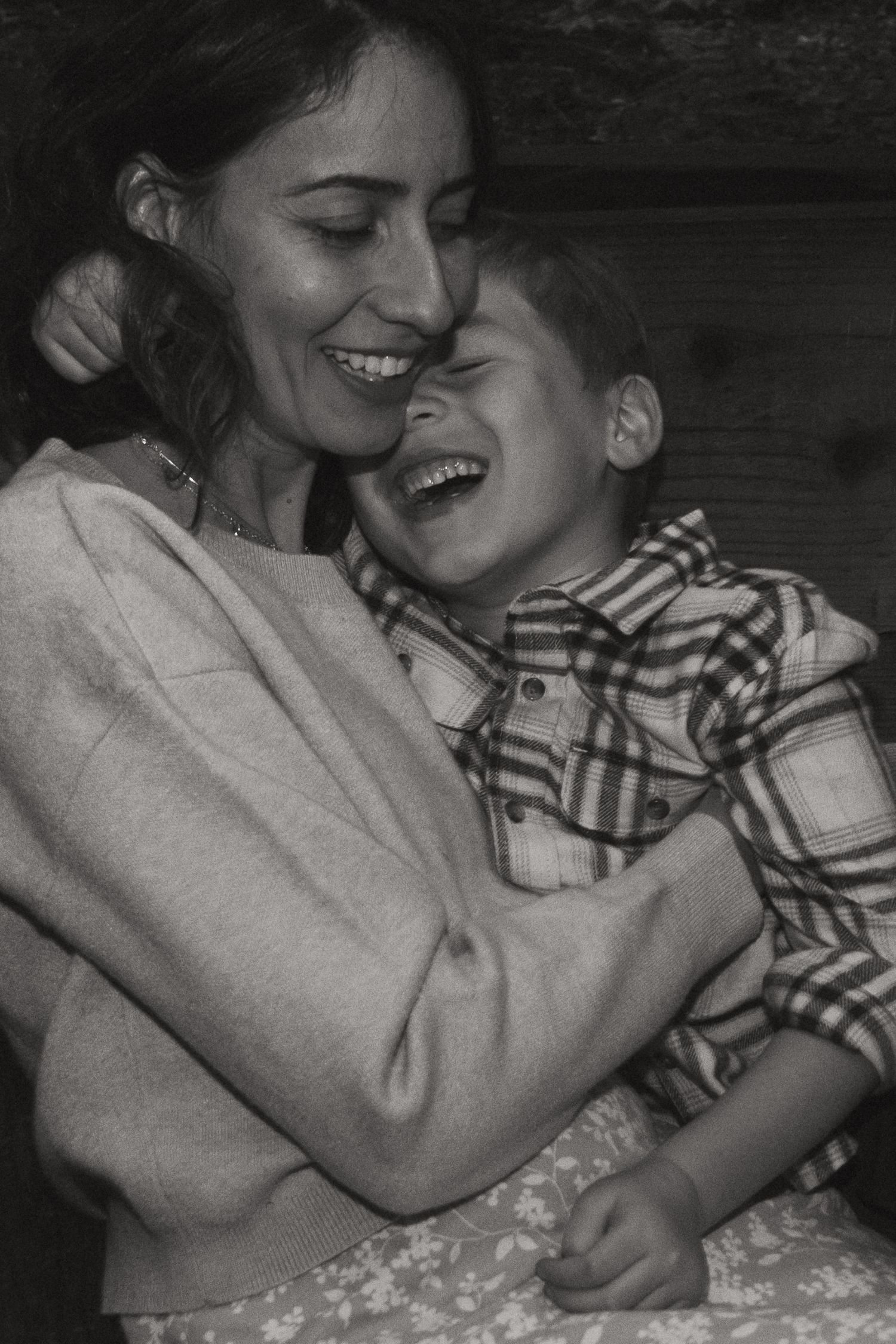 An intimate black and white photo of two people sharing a loving moment in nature.