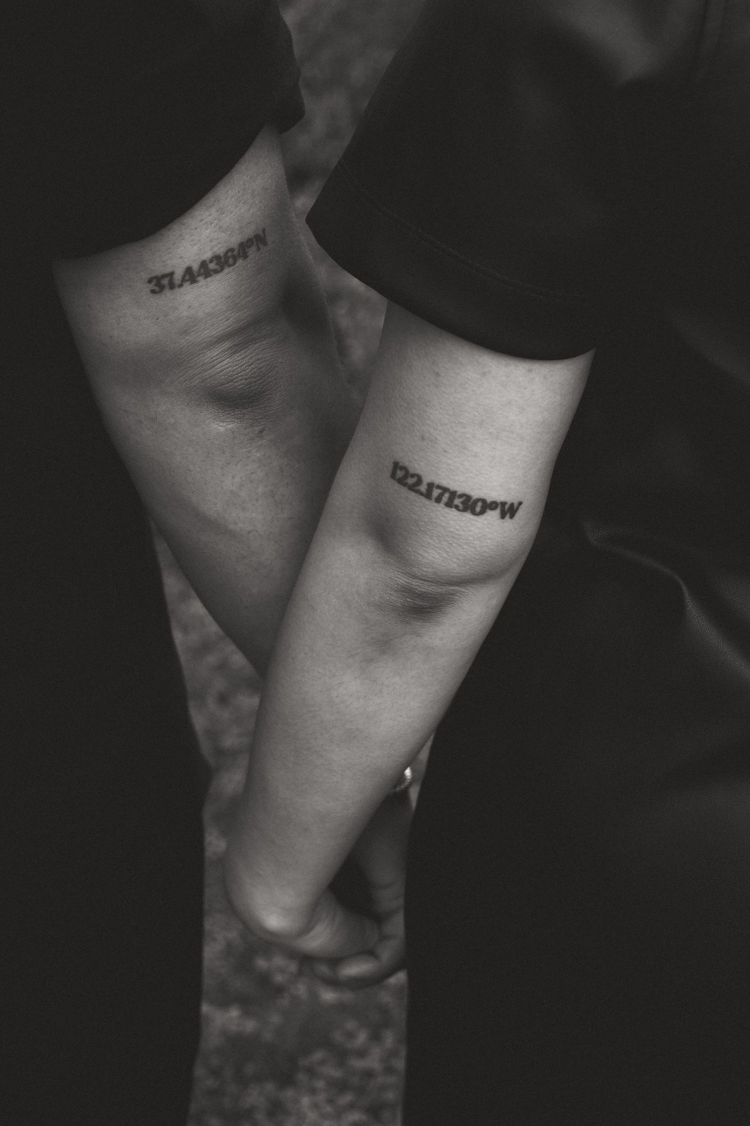 Black and white close-up of matching tattoos on hands.