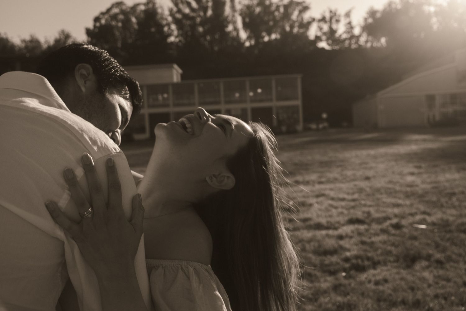 Intimate couple's photoshoot in a sunlit field during golden hour.