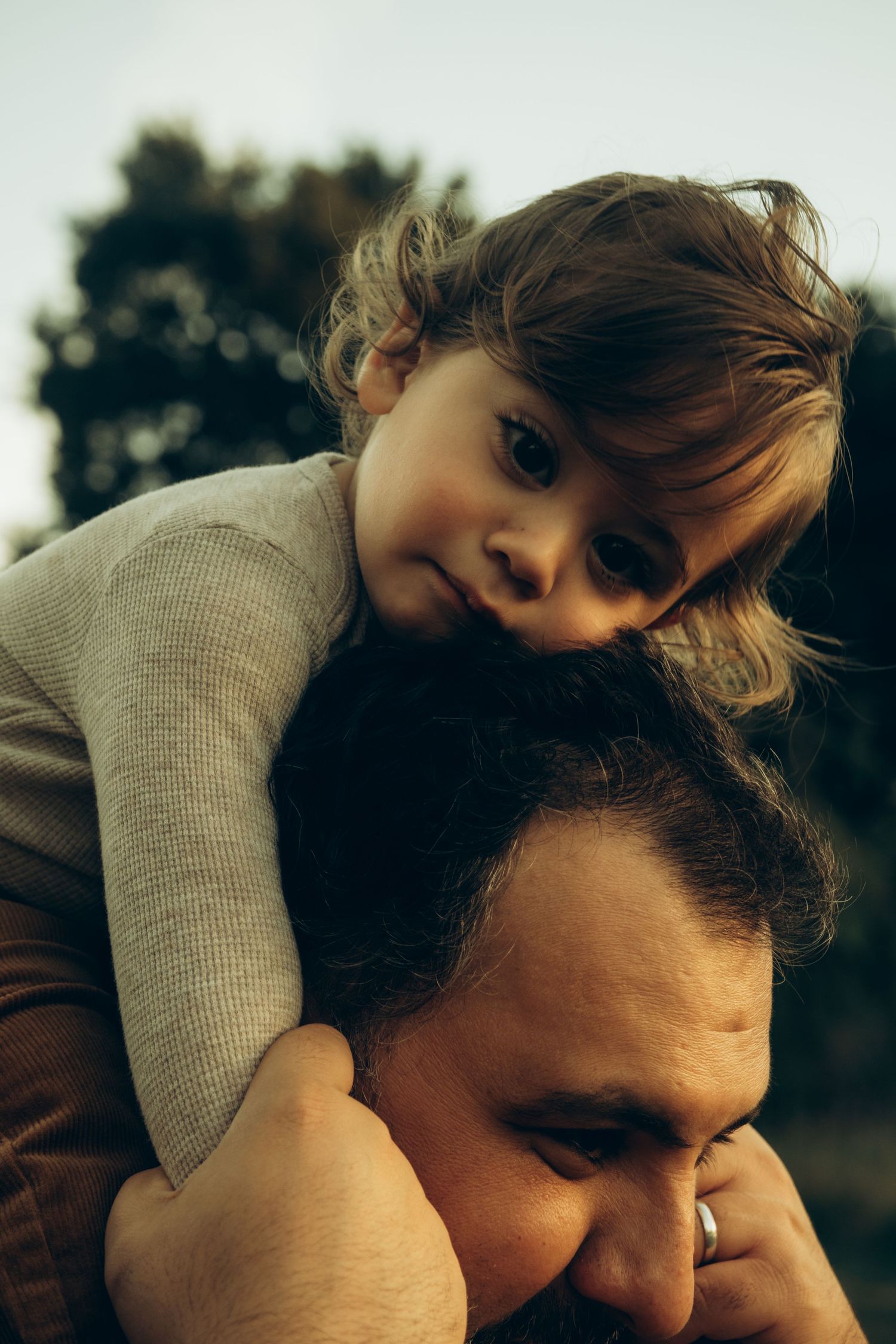 A heartwarming moment between parent and child during an outdoor photoshoot.