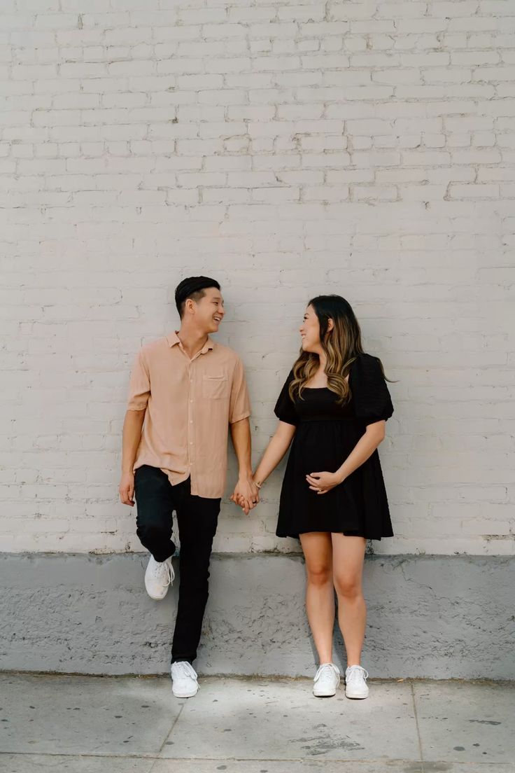 Modern minimalist couple photos against white brick wall showing casual intimacy.