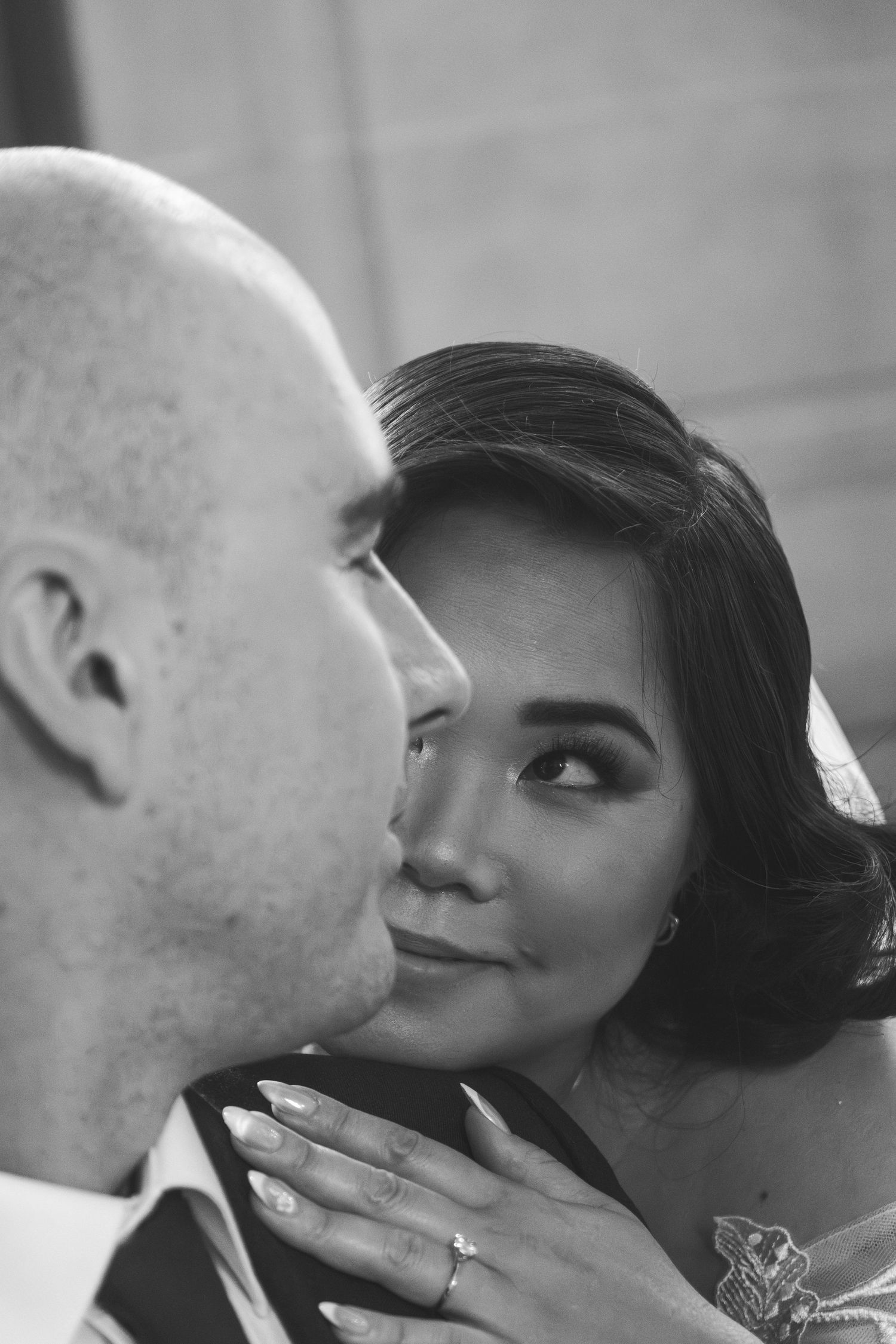 Close-up romantic moment between newlyweds in black and white.