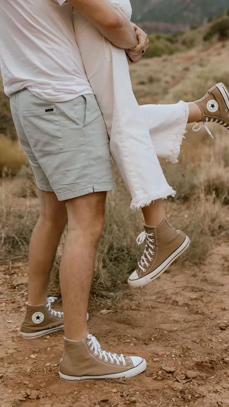 Brown and white Converse sneakers walking on a dirt trail in a natural outdoor setting.