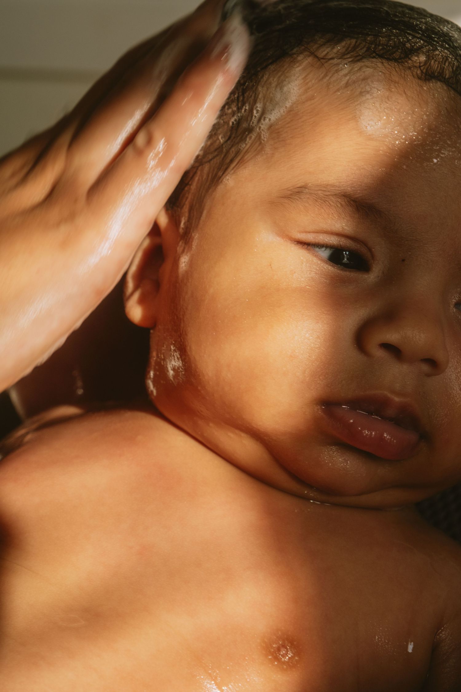 Intimate close-up portrait of a baby with warm, glowing light.